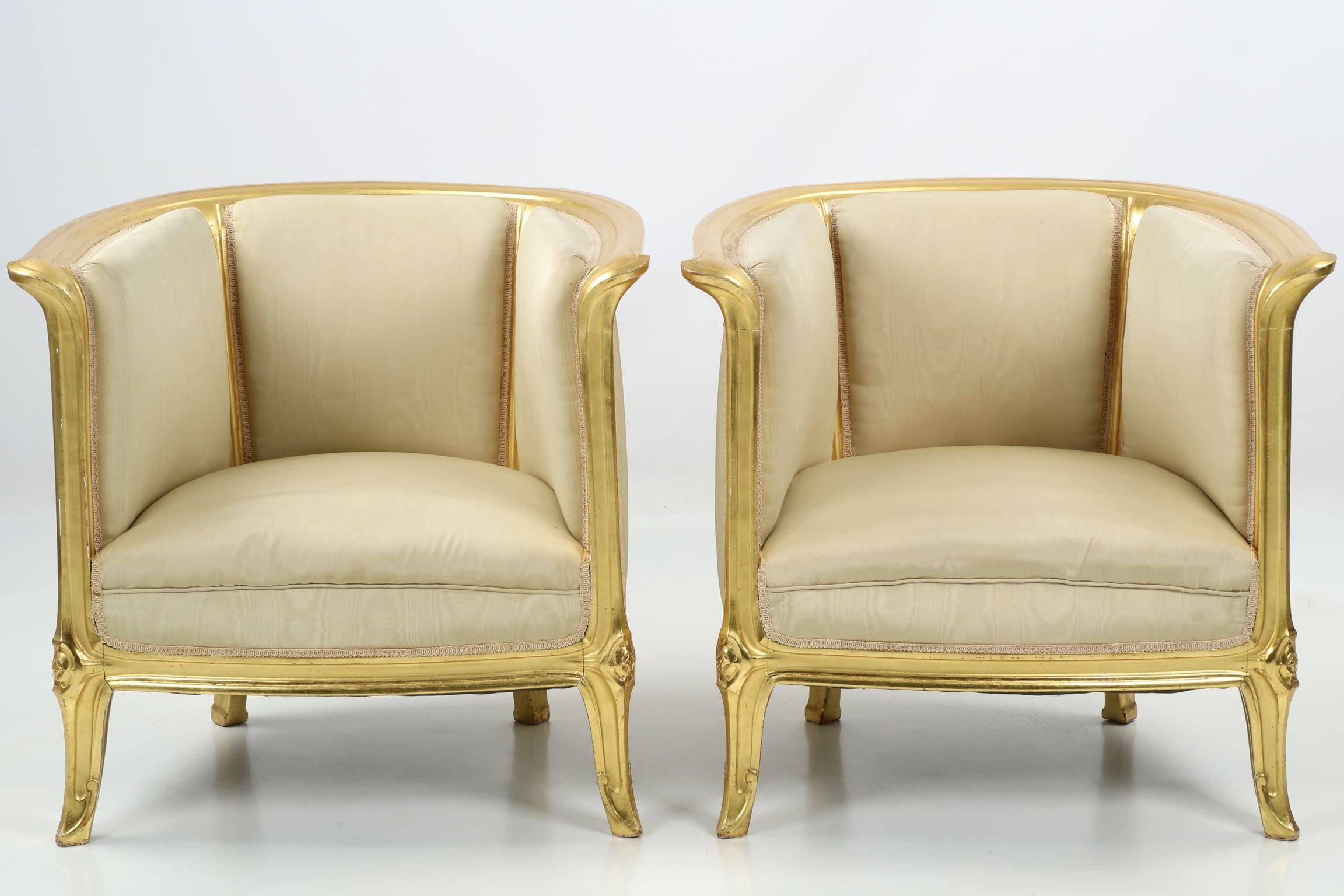 A perfectly designed and proportioned pair of Art Nouveau tub chairs executed in beechwood with brilliant gilt surfaces, they exhibit precise and gorgeous craftsmanship in remarkably heavy frames.  The design is loosely inspired by the curvy nature