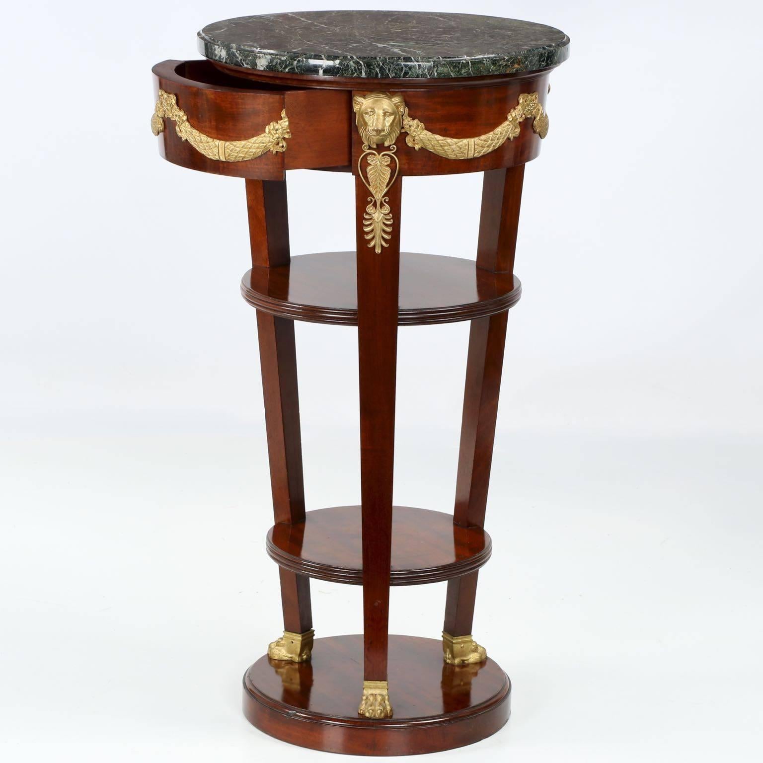 A precise and very finely crafted piece from the turn of the century, this Stand borrows directly from the neoclassical motifs of the first quarter of the 19th century. Each leg is surmounted by highly detailed lion masks flanked by floral swags