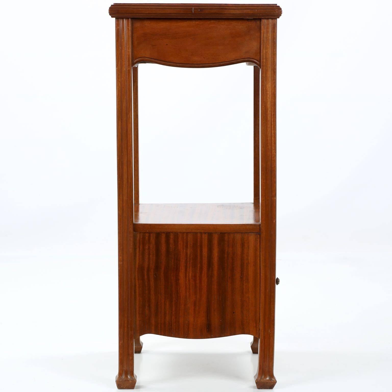A beautiful little side table from the Art Nouveau period, crafted of solid mahogany and mahogany veneers over oak secondary woods. The original rouge marble top is set in a molded rim over a single drawer with gorgeous burled walnut veneer flanked