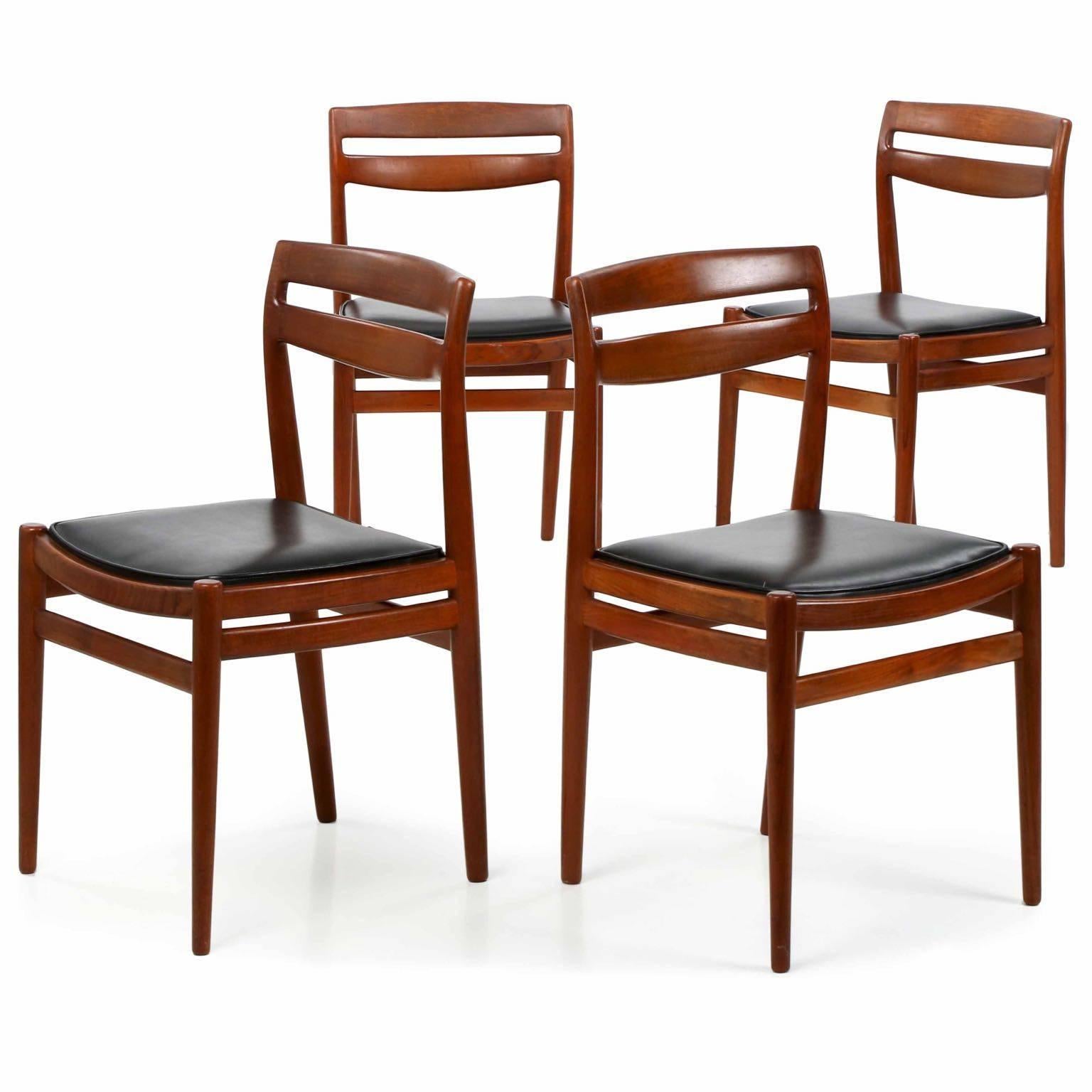 This is a gorgeous set of four Danish mid-century modern teakwood side chairs with crisp lines and clean curvature. The angularity of the chairs is softened by the bow of the crest, the matching curves of the seat rails and the gently tapered turned