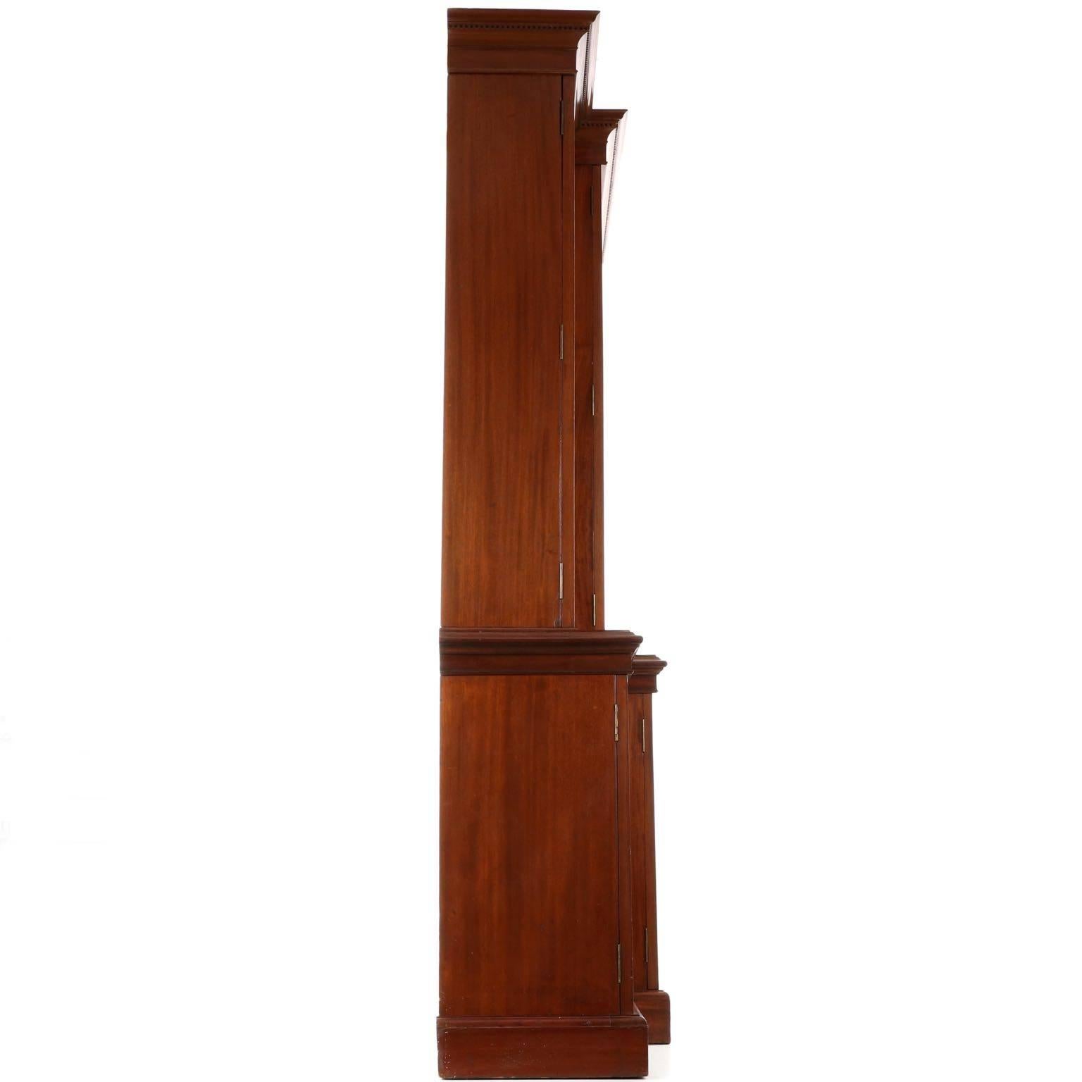 A most fine architectural piece for the formal library or sitting room, this large and impressive American Federal period library bookcase is ingeniously crafted to break down into five easily handled components: the crest, the three bookcase