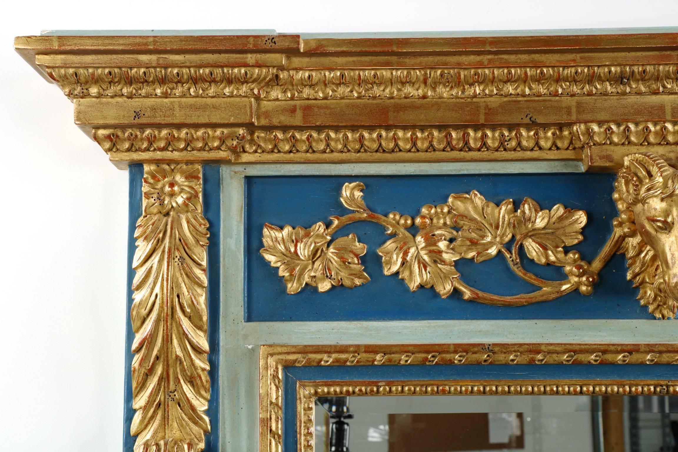 A substantial and impressive piece, this very fine French neoclassical trumeau mirror is in every way a statement piece. With panels of cobalt blue against an old worn teal within borders of gilded carvings, it is a mirror that brings an air of