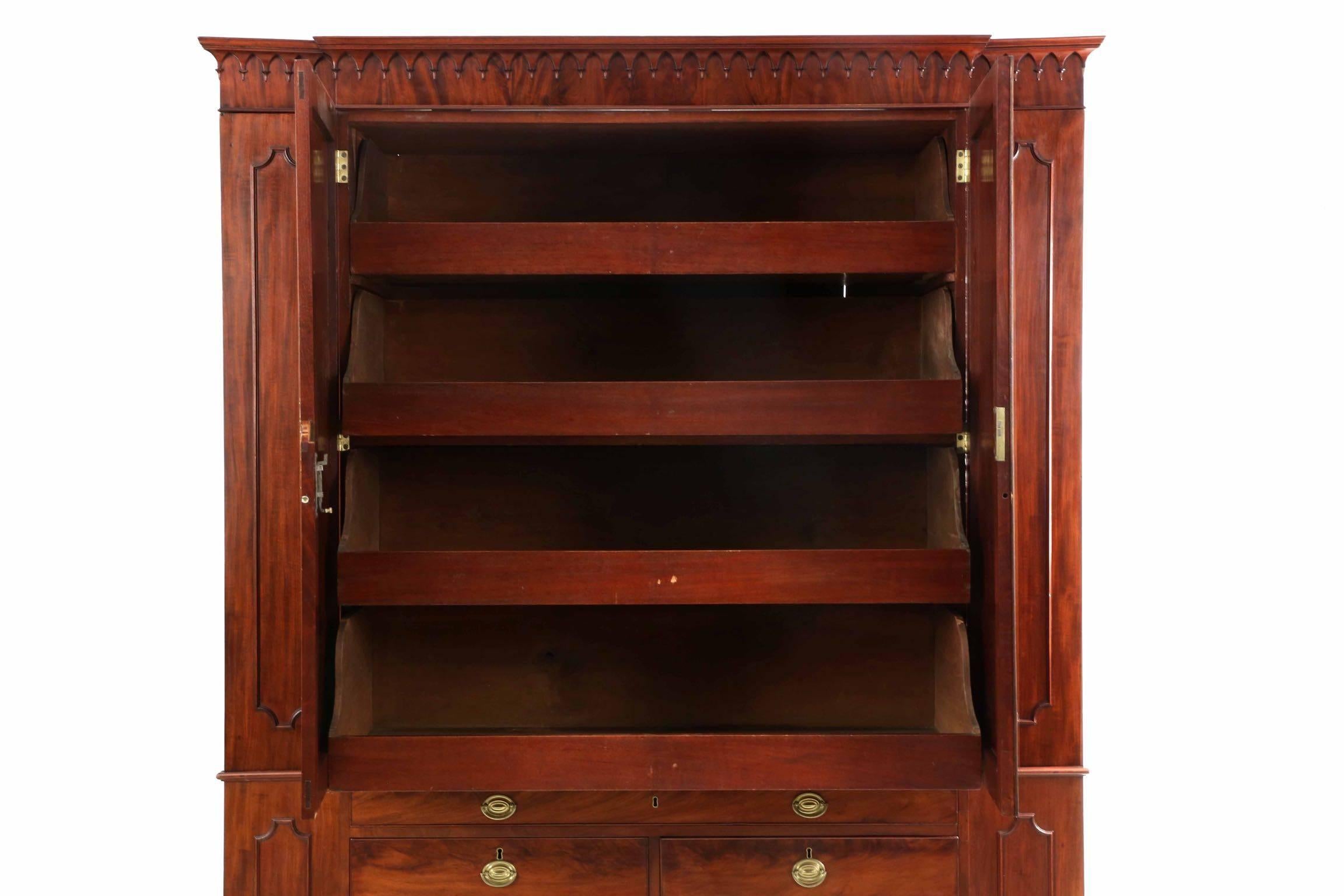 Crafted distinctly in the British tradition, this exceedingly fine piece of case furniture serves many functions: A linen press, a chest of drawers, a secretary desk and is flanked by wardrobe wings. The quality is self evident, the craftsman