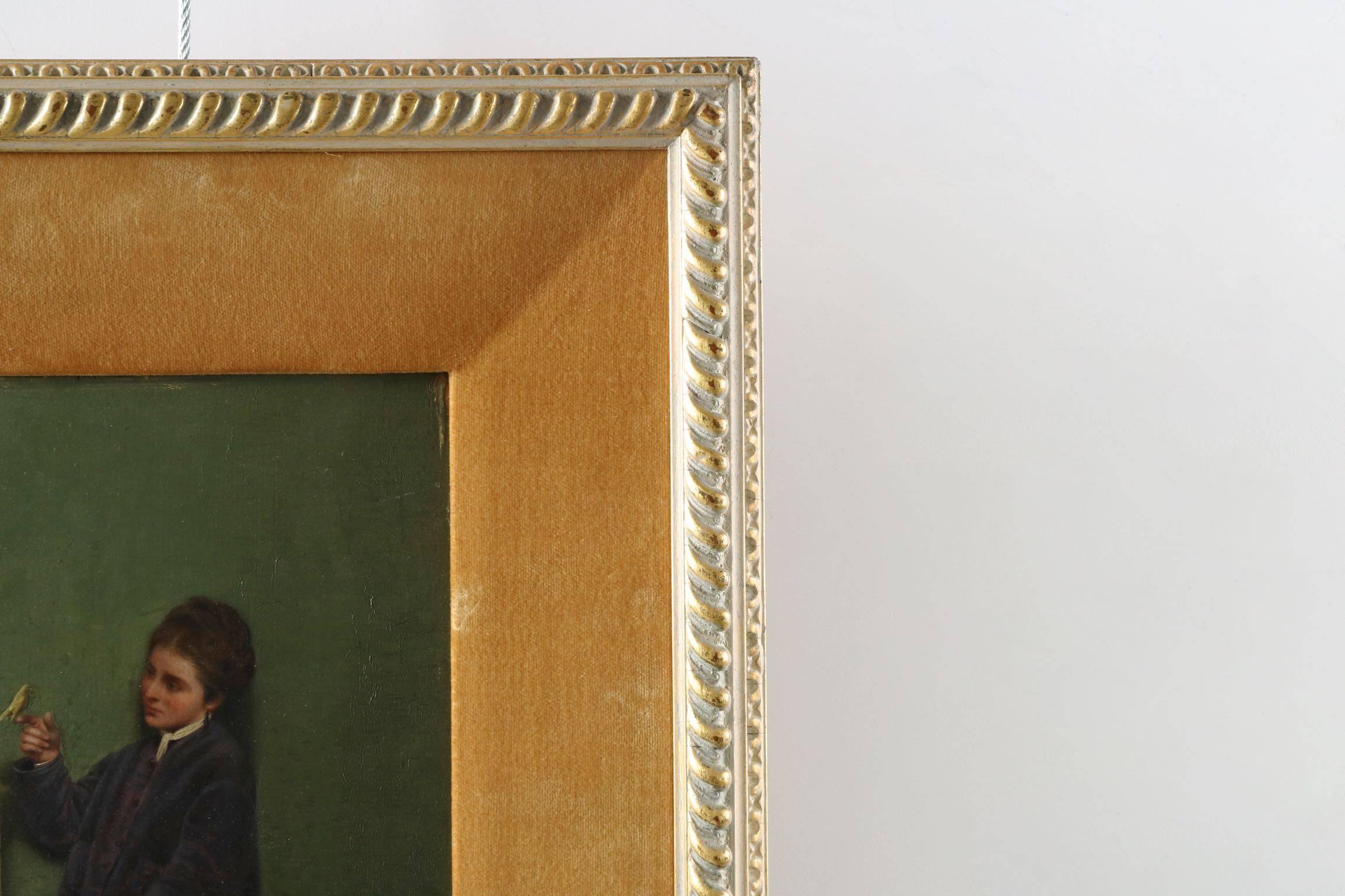 Of equisite detail and realism, this small oil painting on panel captures a young woman standing beside a domed wire cage from which she has just brought out her yellow canary. The scene is perfectly executed with gorgeous rendering of her skin