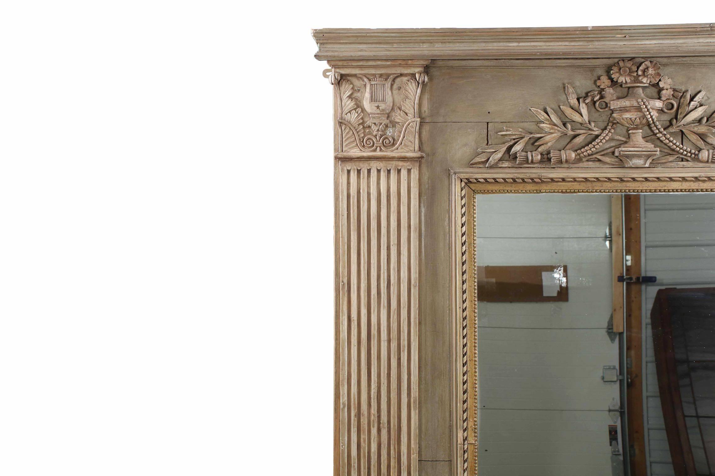 This mirror is a most striking design piece, carefully crafted using old architectural components to lend a natural and authentic surface patina and early classical carvings to the frame. With only a minor projection in the crest, attention is drawn