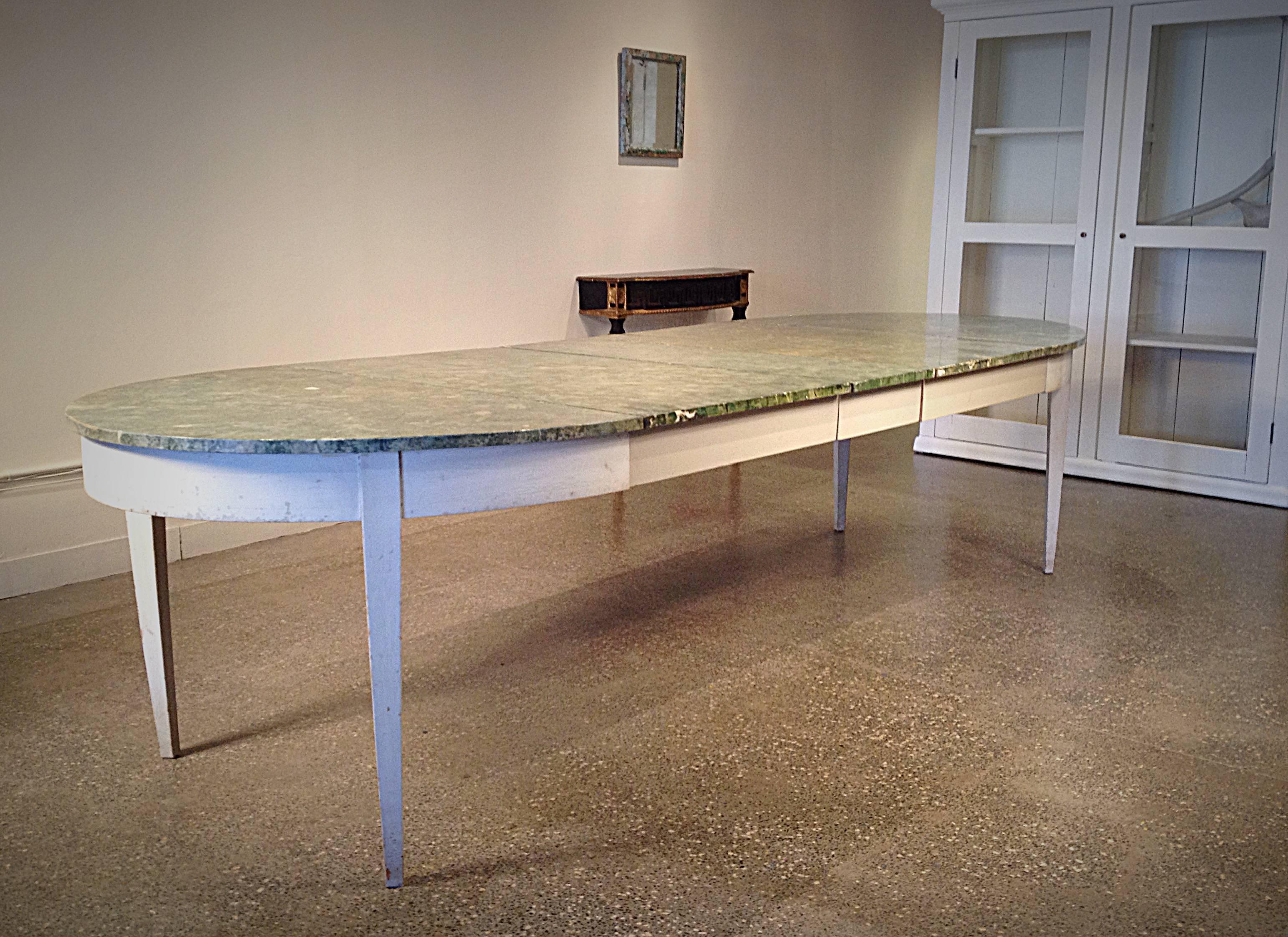 Massive Swedish oval dining table with three leaves. Painted frame, tapered legs, beautiful painted faux green marble top, circa 1850.

Dimensions:
Closed: 54