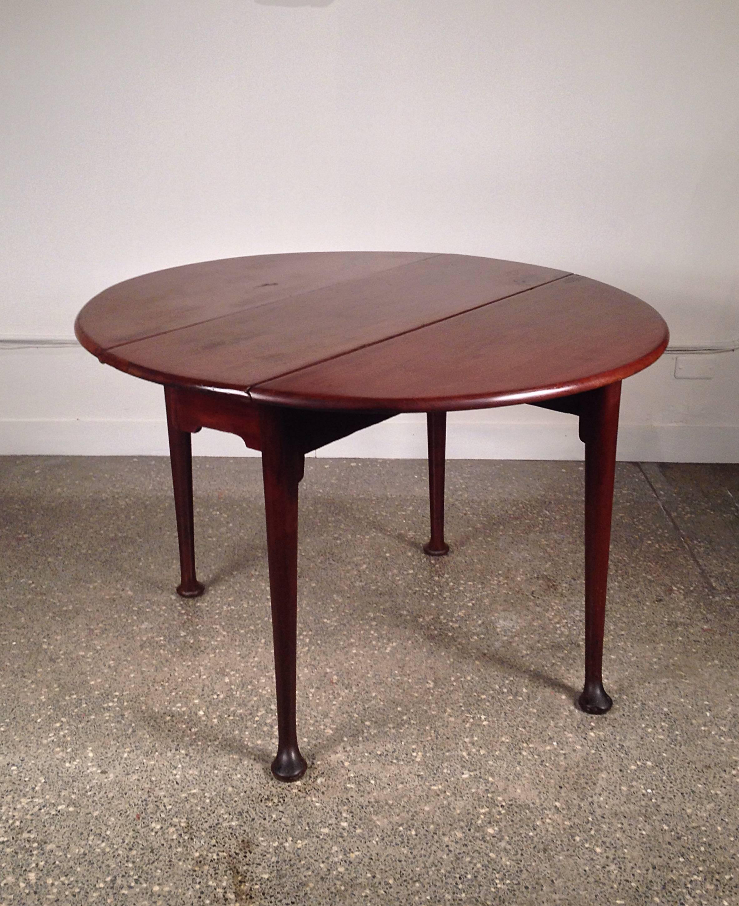 A round mahogany George II drop-leaf breakfast table with beautiful proportions, raised on swing tapered legs and pad feet. 
The table is 14.5