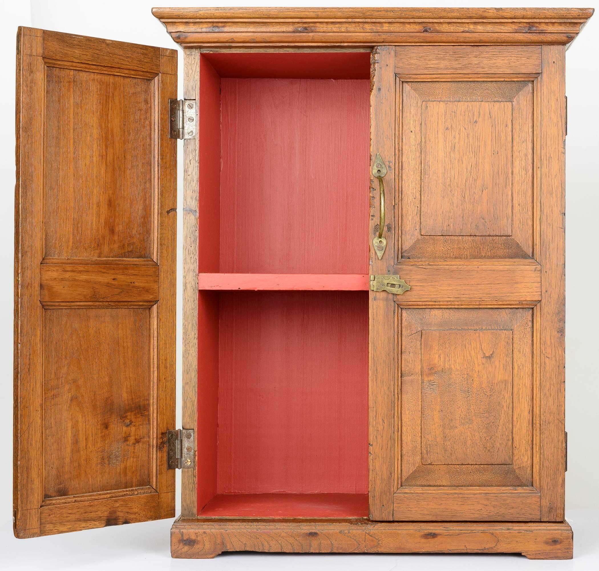 This small country Chippendale cupboard is finely crafted. The22. pair of two raised panel doors with outer molding. The cupboard has crown molding and rests on a base with apron. The brass handle pull and hatch lock are original. The hinges are
