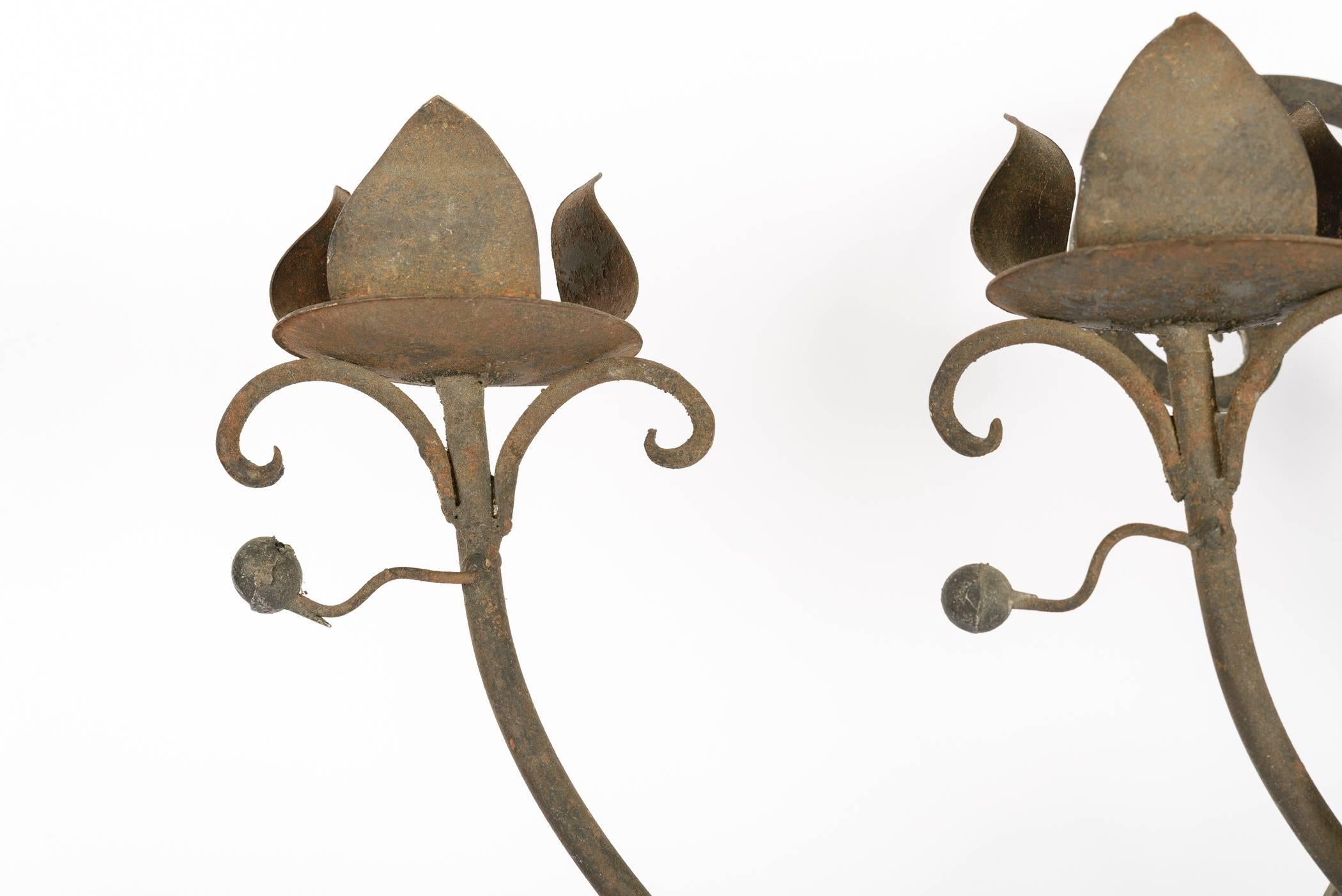This large sconce has seven candles or light cups. The upward arms of the sconce have berry and leaf detail. The candle cups are flower petals. It is drilled to be easily electrified, but lovely, too, for wax candles.