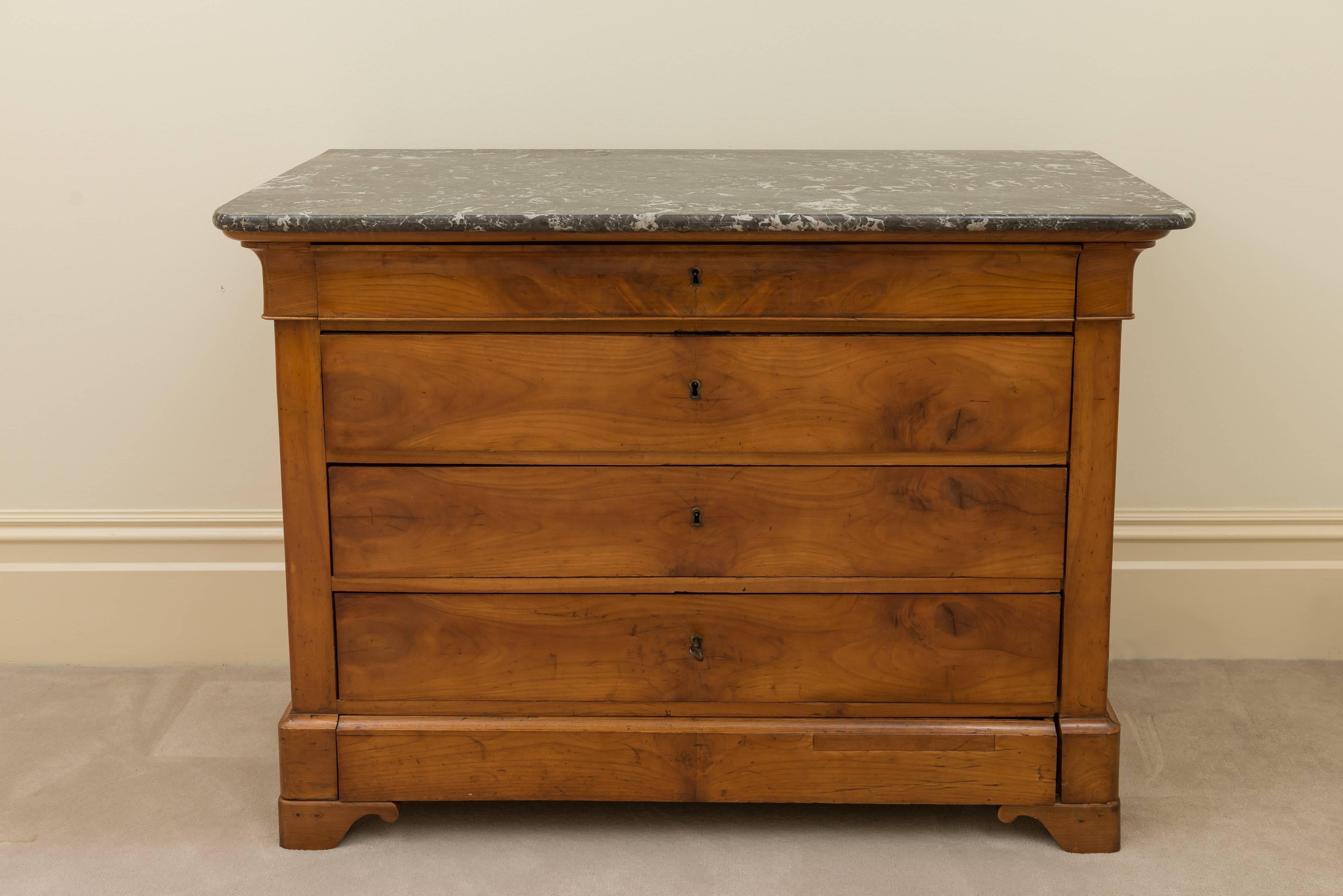 The four-drawer 19th century commode has matched burled walnut veneer. The apron and top drawer have a rolled top edge. The side rails have a bead detail and rest on beveled plinth and foot with curl detail. The sides are solid walnut.
