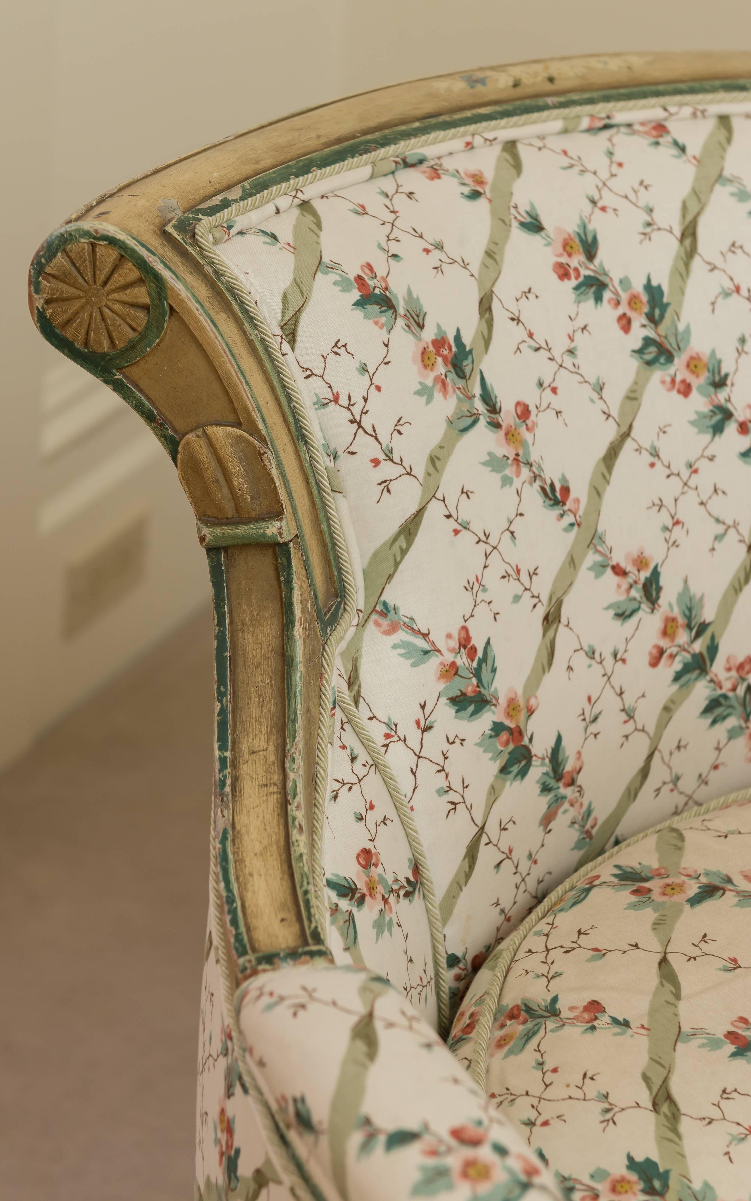 Directoire upholstered ladies' bergère with down cushion and sold scroll back. The chair has upholstered arms resting on balustrade columns and scabbard legs with block with rosette detail. The two tone paint is original. The Lee Jofa fabric is a