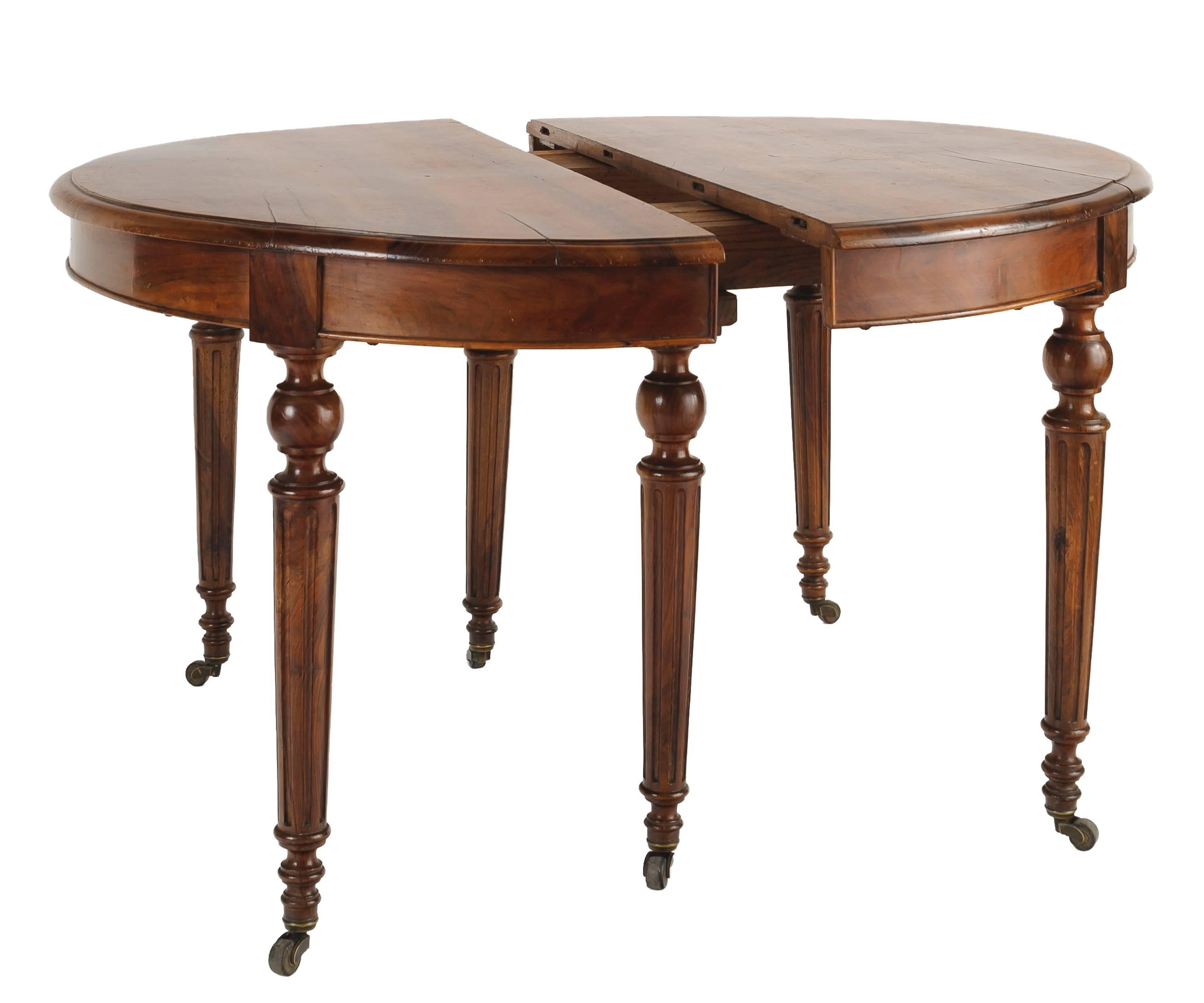 French round walnut table with ogee edge. The walnut wood has a wonderful patina and beautiful markings. The six legs are turned and tapered with ball and flange at top. The legs have channelled detail and sit on original bronze casters. There are