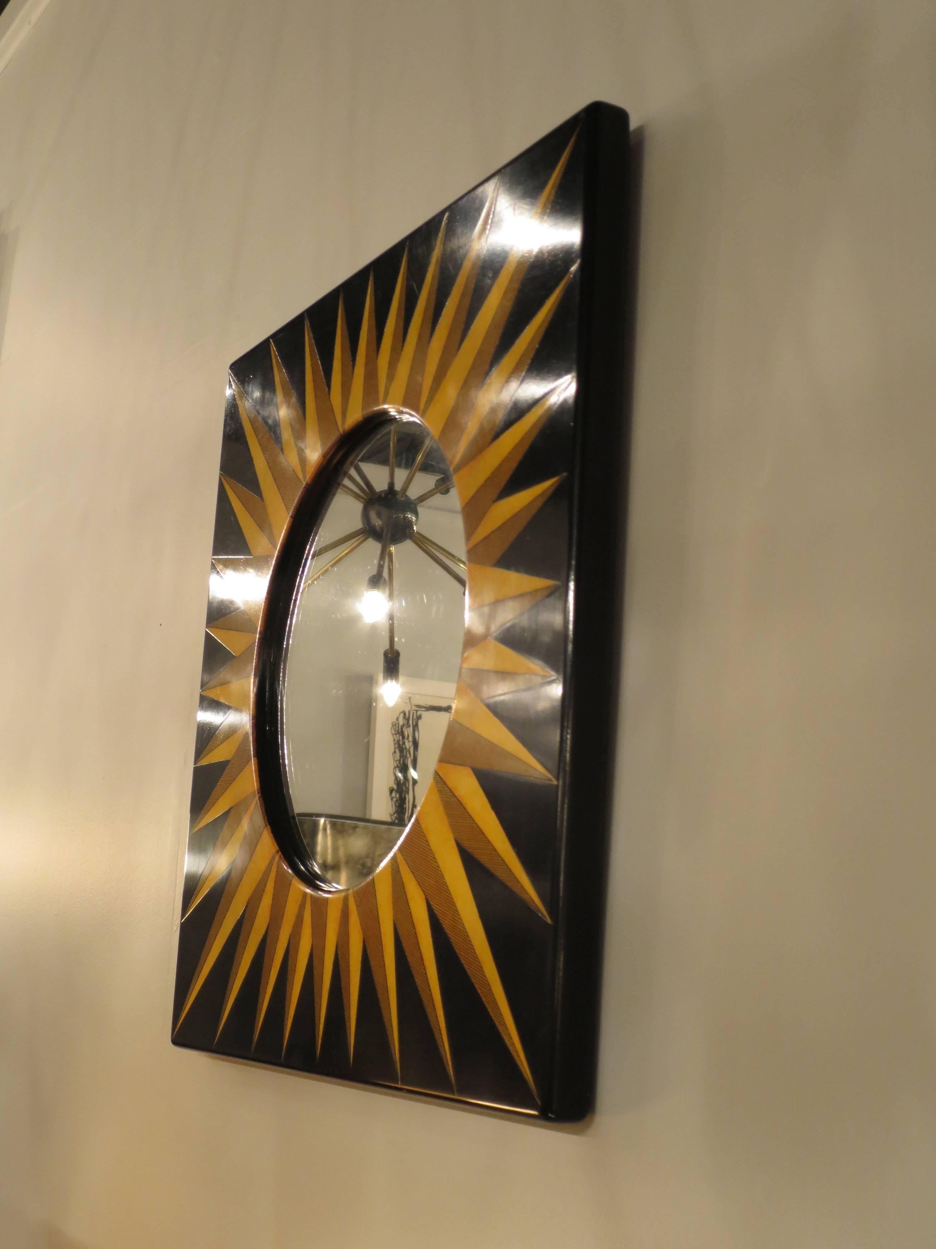 Decorative black and gold sunburst mirror by Fornasetti, Italy, 1950s.