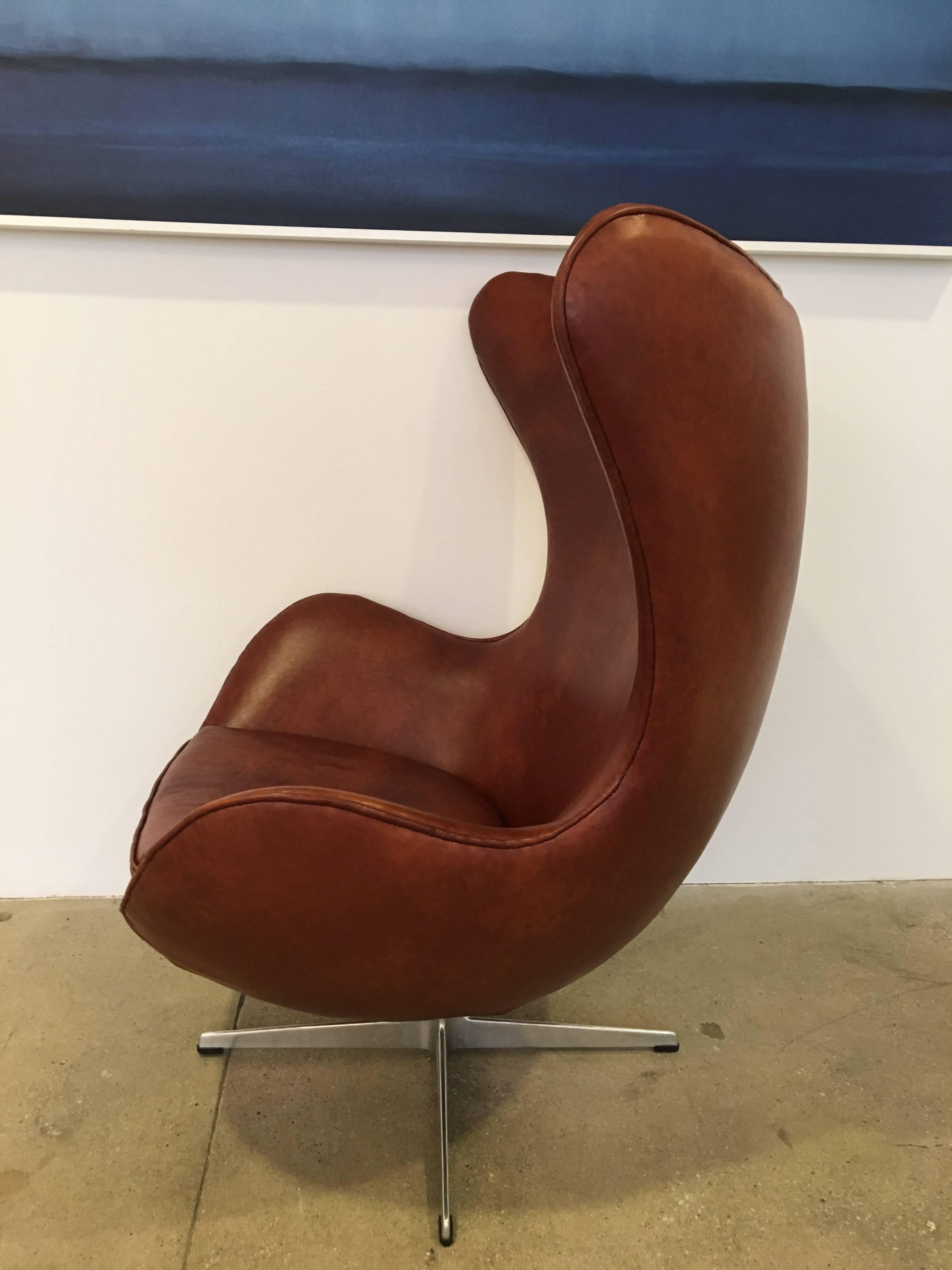 Original Arne Jacobsen Egg Stuhl:: hergestellt von Fritz Hansen im Jahr 1965. 
Der Stuhl wurde später mit patiniertem braunem Leder bezogen. Darunter befindet sich ein Aufkleber des Herstellers.