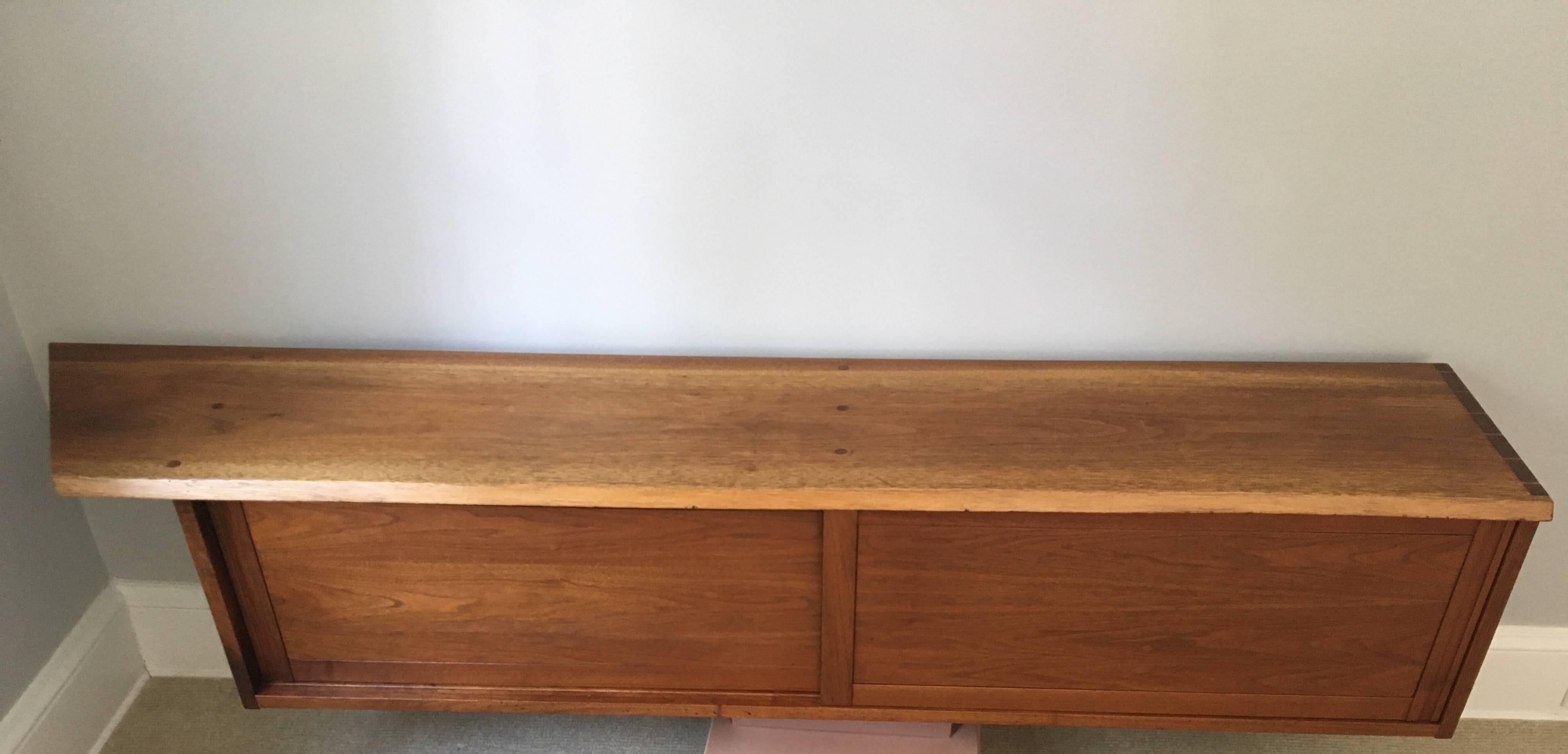 Exceptional walnut, wall handing console by George Nakashima, 1965. Two sliding doors and a shelf on the left side. Beautiful live edge and craftsmanship. Great apartment size.