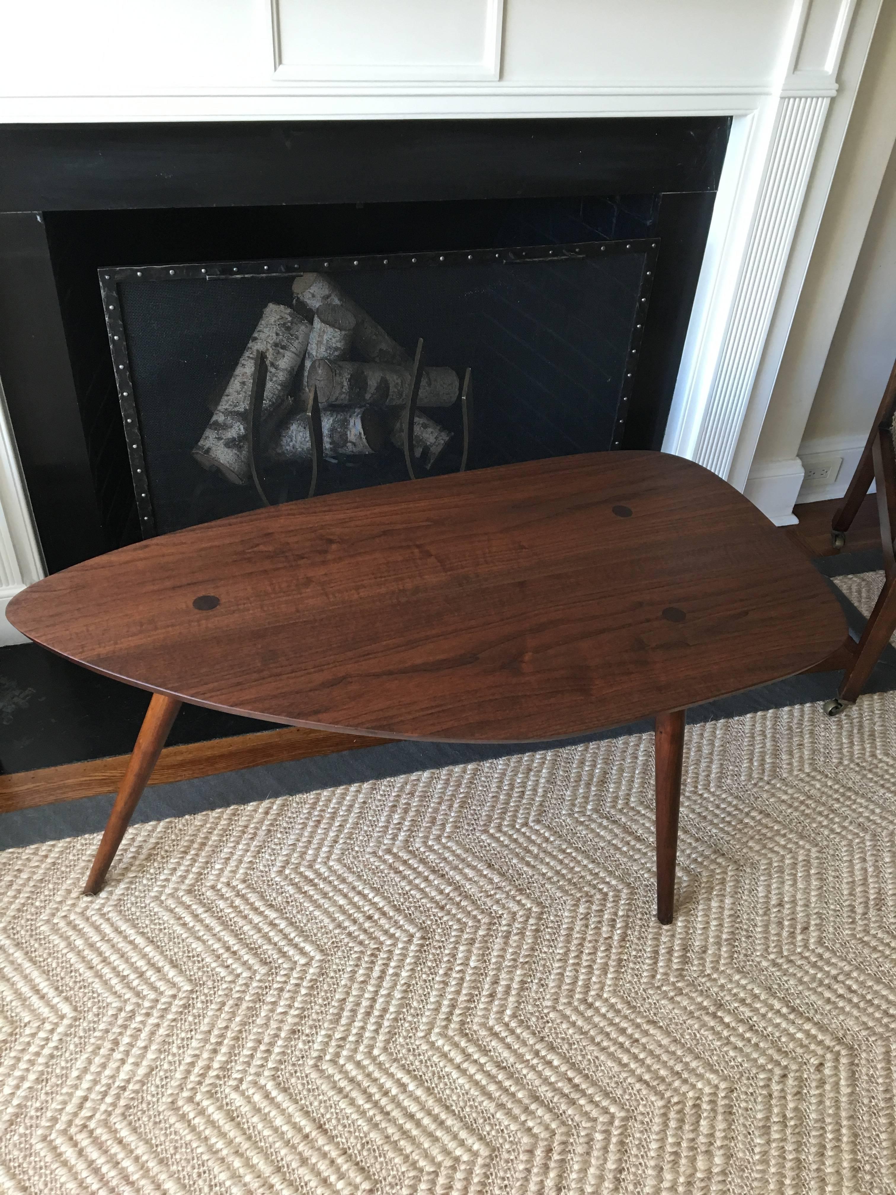 Guitar pick shaped, walnut sculpted table by New Hope studio craftsman Phillip Lloyd Powell, 1960s.
The extra-long top is supported by spindle and tapered legs, beautifully showing joint details and expressive grain.
Table has been cleaned and