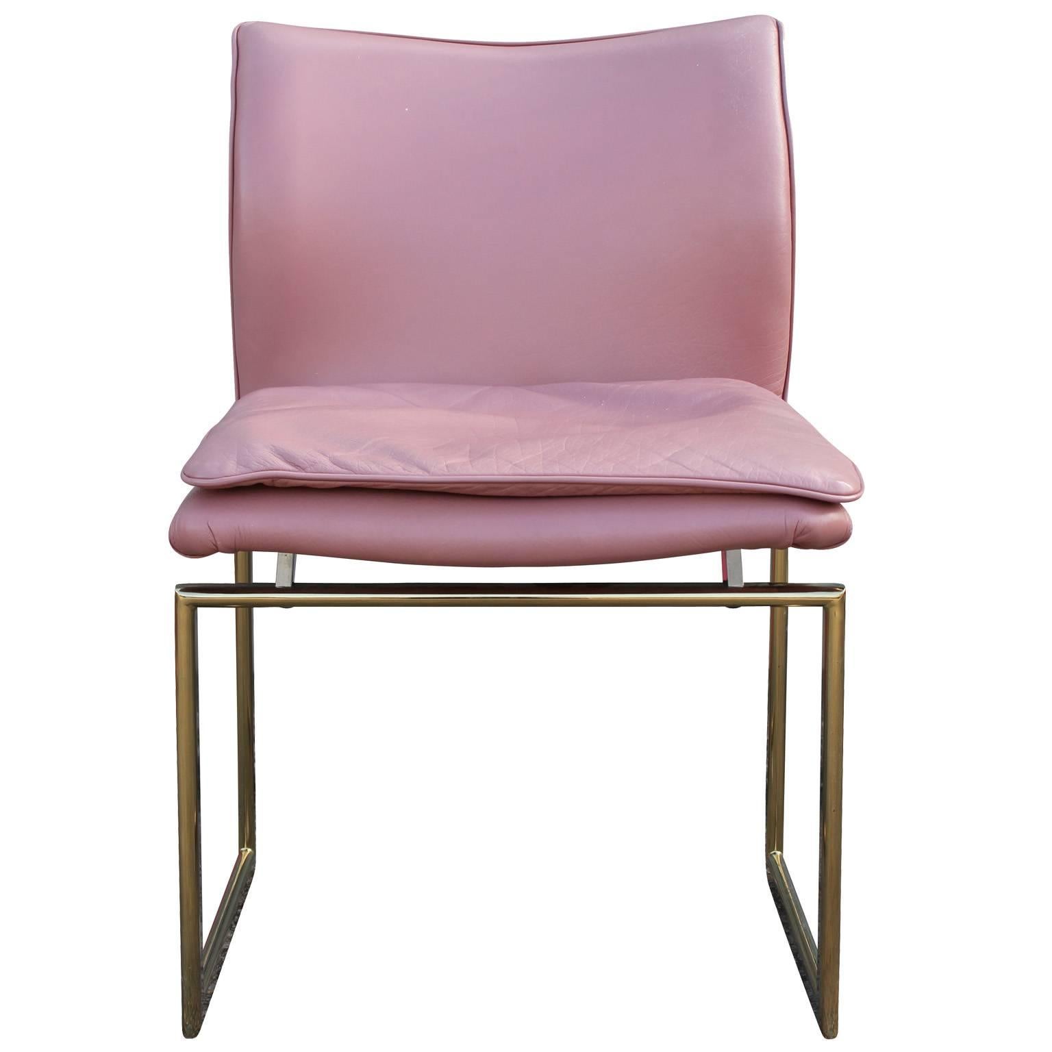Incredible set of Pieff and Co. dining chairs. Architectural brass frames nicely contracts the ergonomic curves of the seats. Seats are upholstered in a mauve pink leather. Leather is in good shape with some minor sun fading. Chairs are marked 