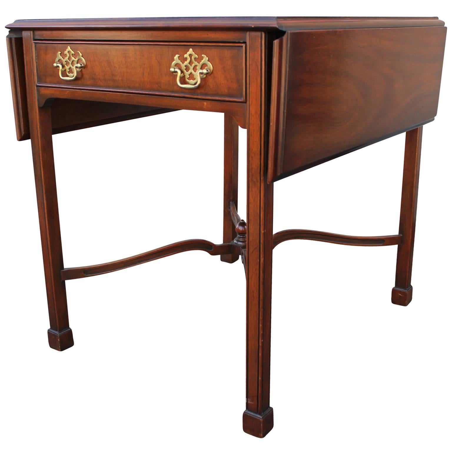 Elegant pair of Kindel pembroke or drop-leaf side tables. Mahogany tables have a lovely attention to detail and ornate brass hardware. A single drawer provides storage. Table width goes from 25