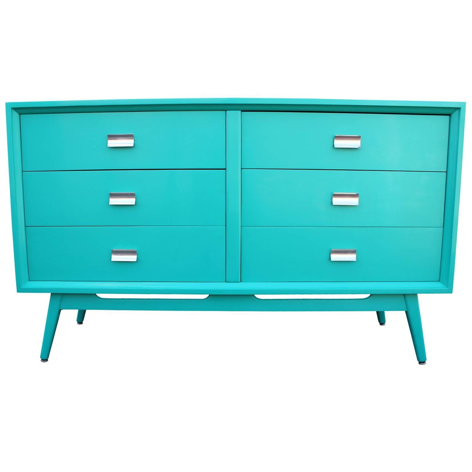 Incredible six-drawer dresser. Dresser has been expertly restored in a teal or turquoise lacquer. Shiny chrome pulls. Splayed and tapered base has negative space accents adding lightness to the piece. Stunning from all angles.