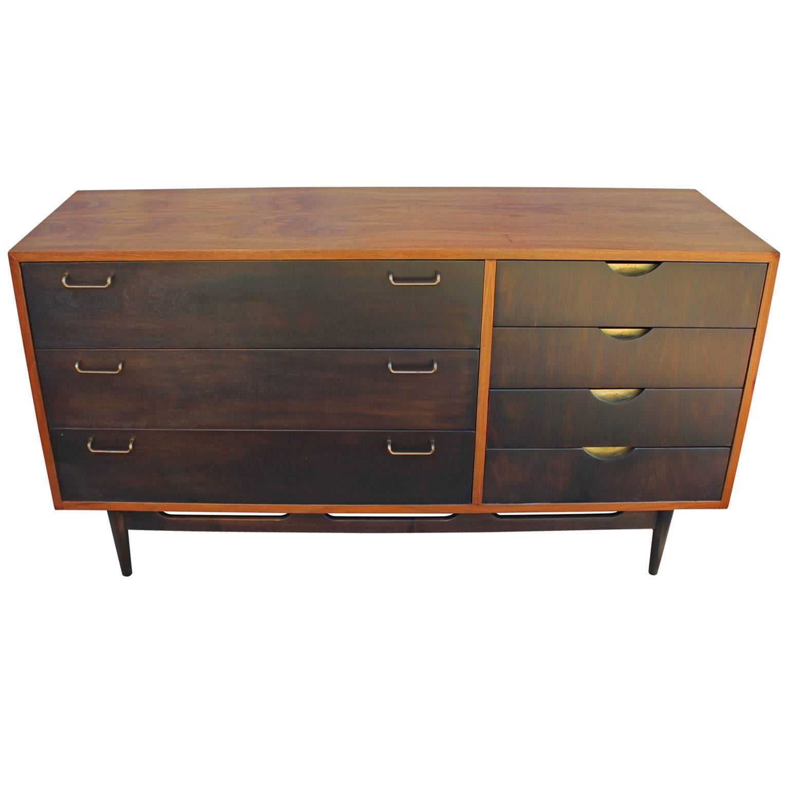 Lovely seven-drawer dresser with aged brass accents. Dresser is freshly finished in a two tone walnut, with the case a medium walnut and the drawer fronts a darker shade. Top two drawers are sectioned for easy organization.