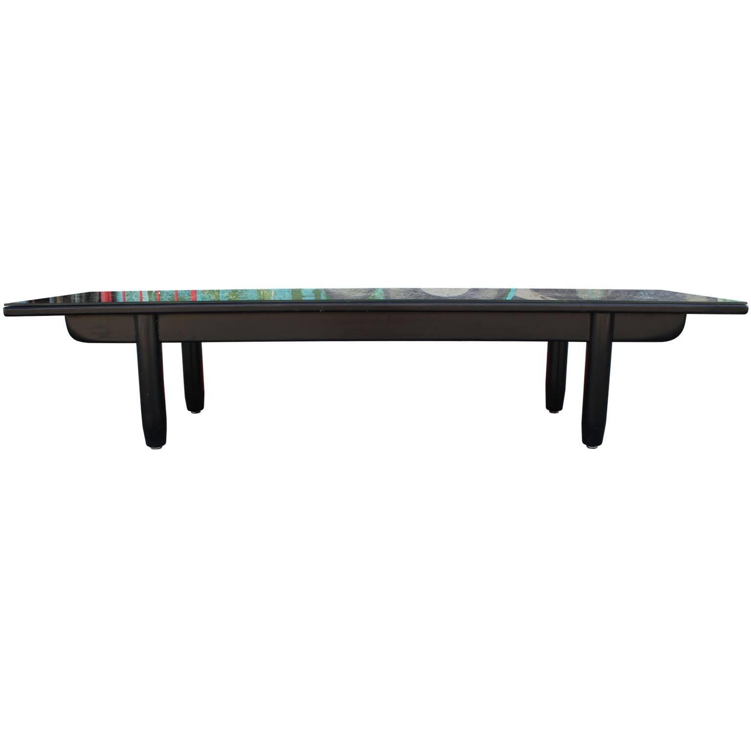 Incredible coffee table with a reverse painted glass top. Top has an incredible design and depicts a motif of horses and birds on an abstract gold leafed backdrop. Fabulous piece of art. Simple black legs complete the piece. Excellent focal point in