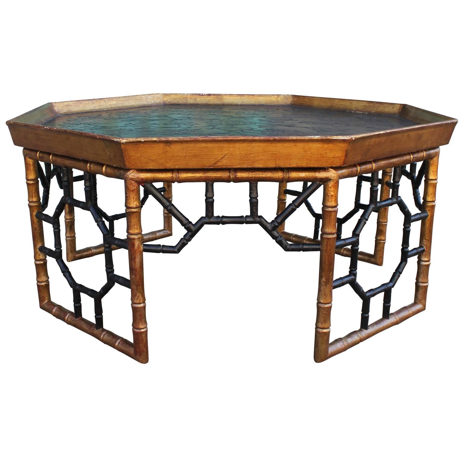 Stunning octagon shaped Italian coffee table. Tray top depicts a gilt floral motif and is edged in gold leaf. Gold leafed faux bamboo base has retains a vintage patina. Lovely piece would add a glam, Hollywood regency touch to any space. The top is