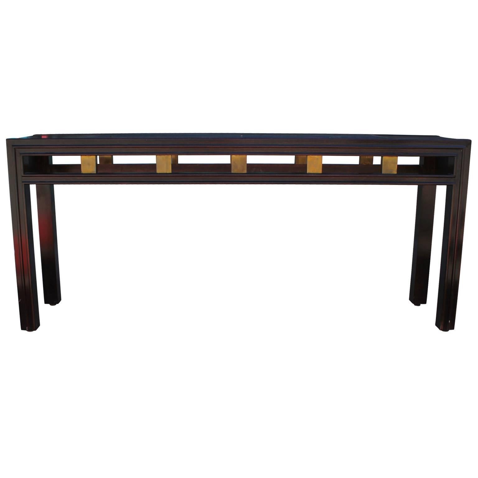 Wonderful console table with brass and burl accents. The table has smoked glass which has a small chip. We can put Lucite in place of the glass for a small up charge. In nice vintage condition.