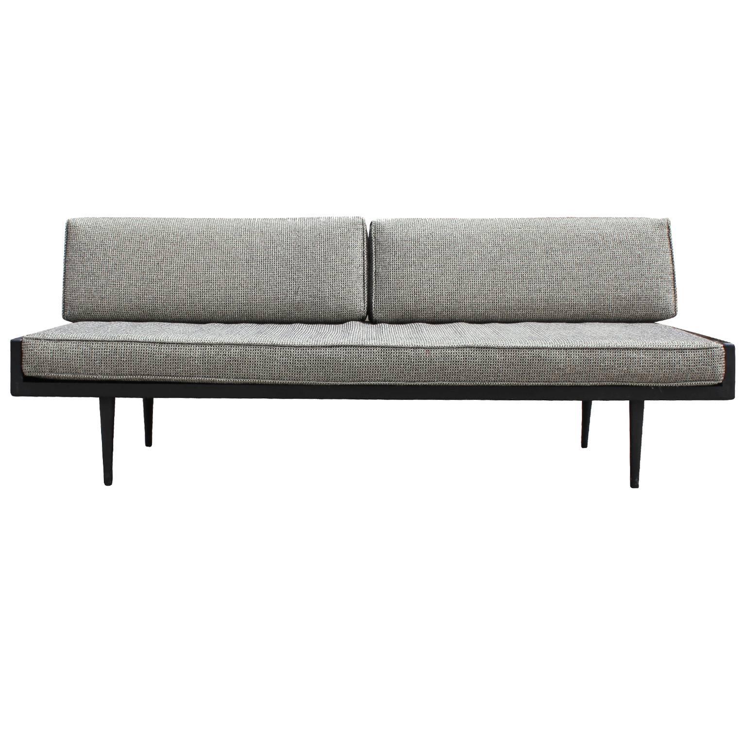 Stunning armless sofa in the Danish style or George Nelson. Wood frame in black lacquer. Upholstered in original fabric which could use updating.