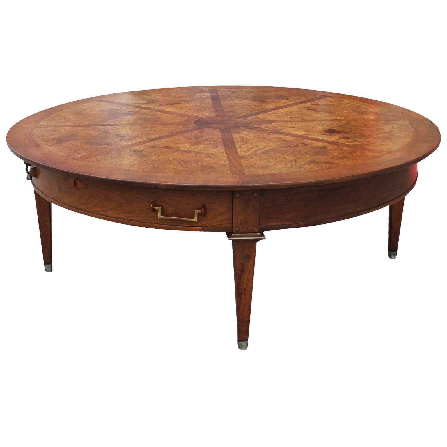 Excellent round coffee table by Mastercraft. Transitional style table has beautiful inlaid burl detailing. A single drawer is accented with copper hardware.