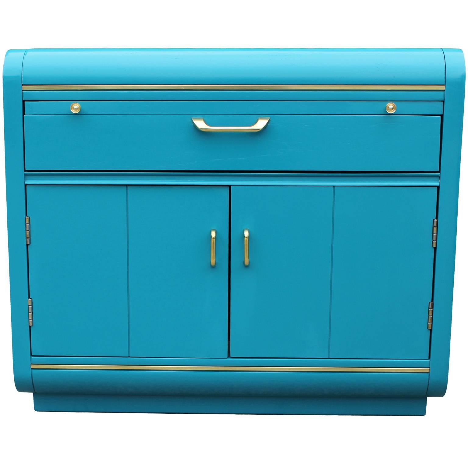 Bold pair of night stands freshly finished in a glossy turquoise lacquer with brass accents. Tables feature a pull out shelf for drinks. A single drawer and open cabinet space provide ample storage.