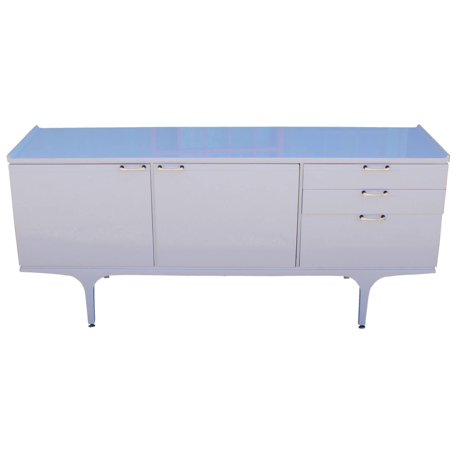 Ultra luxe credenza or sideboard expertly finished in a smooth and glossy pale lavender lacquer. Credenza has excellent lines with a curved lip on the top and curved legs. Chrome hardware with black accents. Two cabinet doors open to reveal single