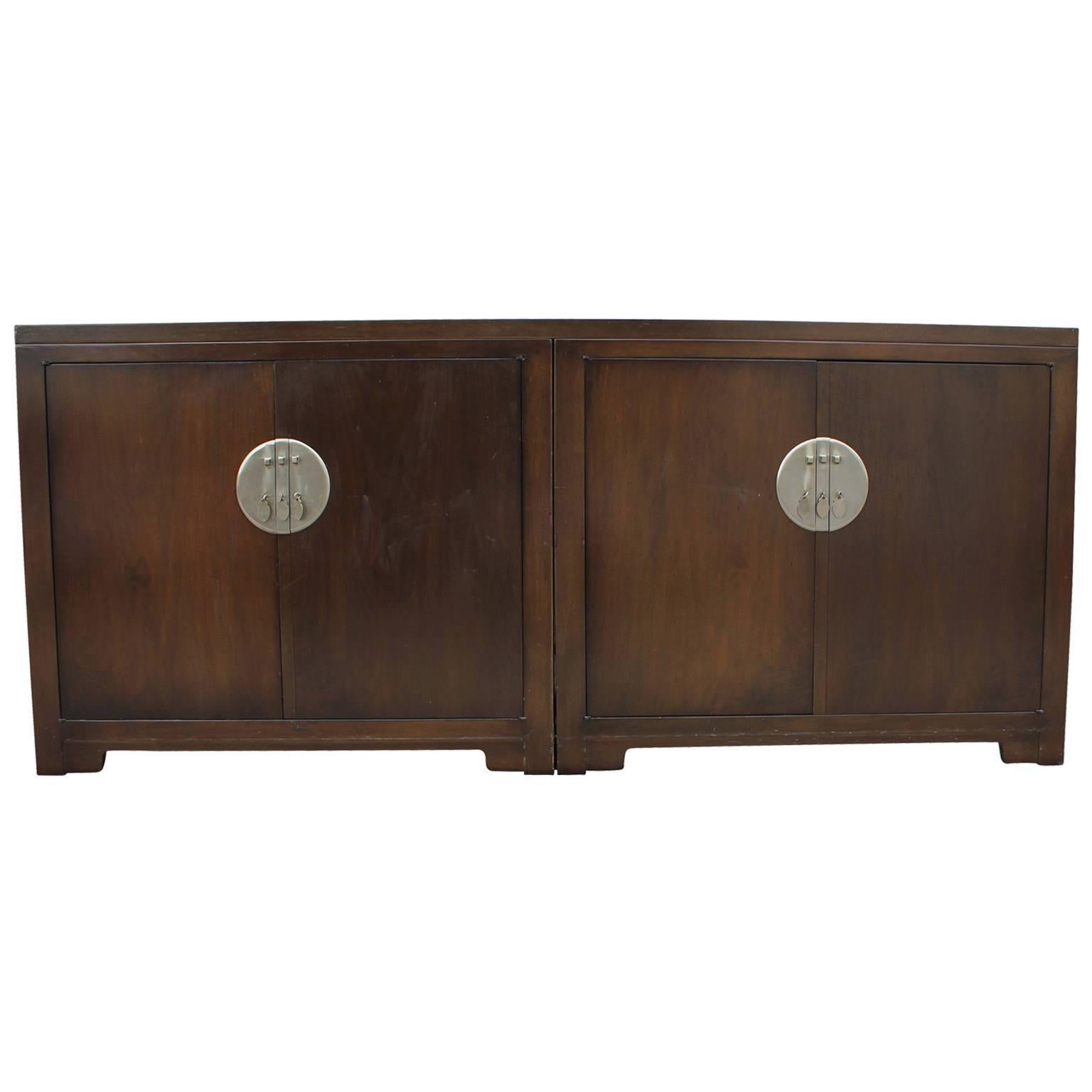 Excellent modular sideboard or pair of cabinets by Baker for the Far East Collection. Cabinets are joined by a removable table top. Cabinets are accented with large, Asian inspired nickel escutcheons. One cabinet features three drawers and the other