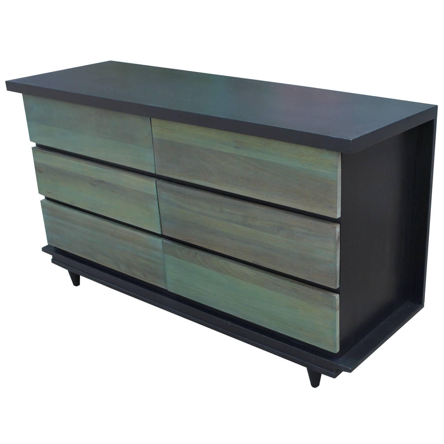 Sleek, clean lined six-drawer dresser in an unusual custom two-tone finish. Case is finished in an ebony stain and drawer fronts are in a sea green aniline dye. Six drawers provide excellent storage. Excellent POP to any space.