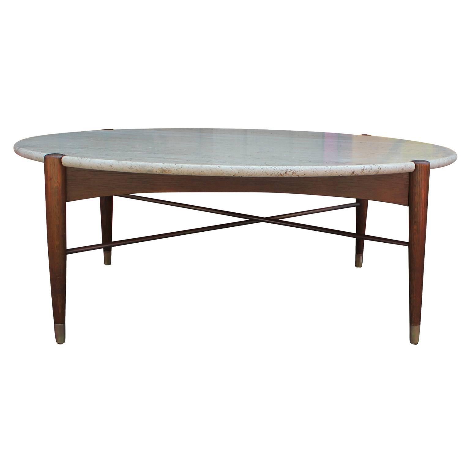 Beautiful round coffee table by DUX attributed to Bruno Mathsson. Travertine top has a beautiful grain. Sculptural walnut base with X-stretcher. Tapered legs are capped in brass. Excellent in a Mid-Century, transitional, or Scandinavian Modern