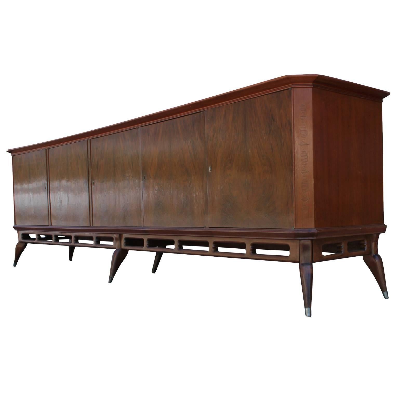 Huge 10 foot Argentinian sideboard. Figured mahogany drawer fronts have an excellent grain. Fruitwood inlays. Sculptural base has lovely curved lines and negative space. Two left cabinets open to a single shelf. Center cabinet opens to reveal four