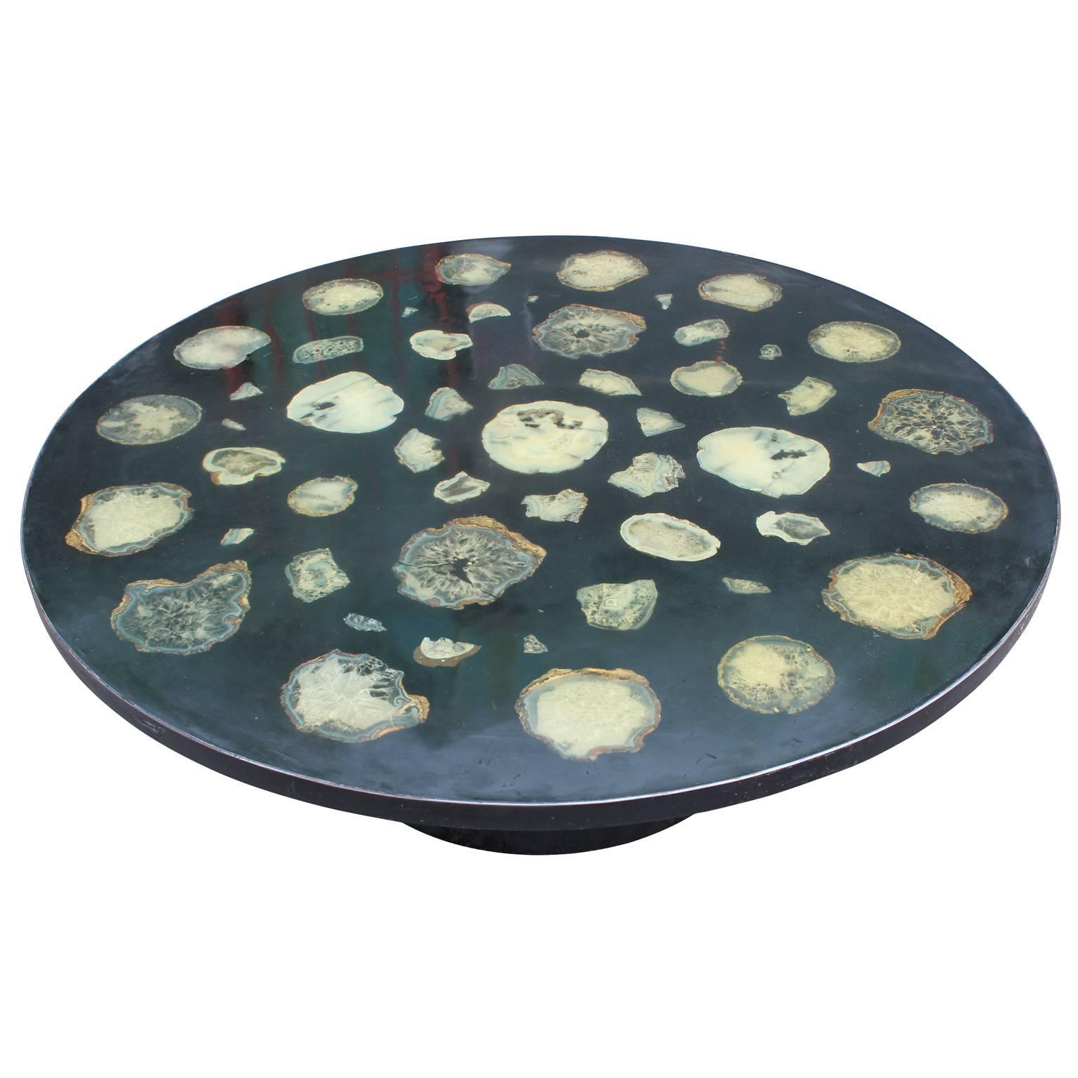 Stunning round coffee table. Table top features sliced agate artfully arranged in resin. Table top rests on a steel drum base. A fabulous statement piece for any space. Attributed to famed artist Ado Chale.