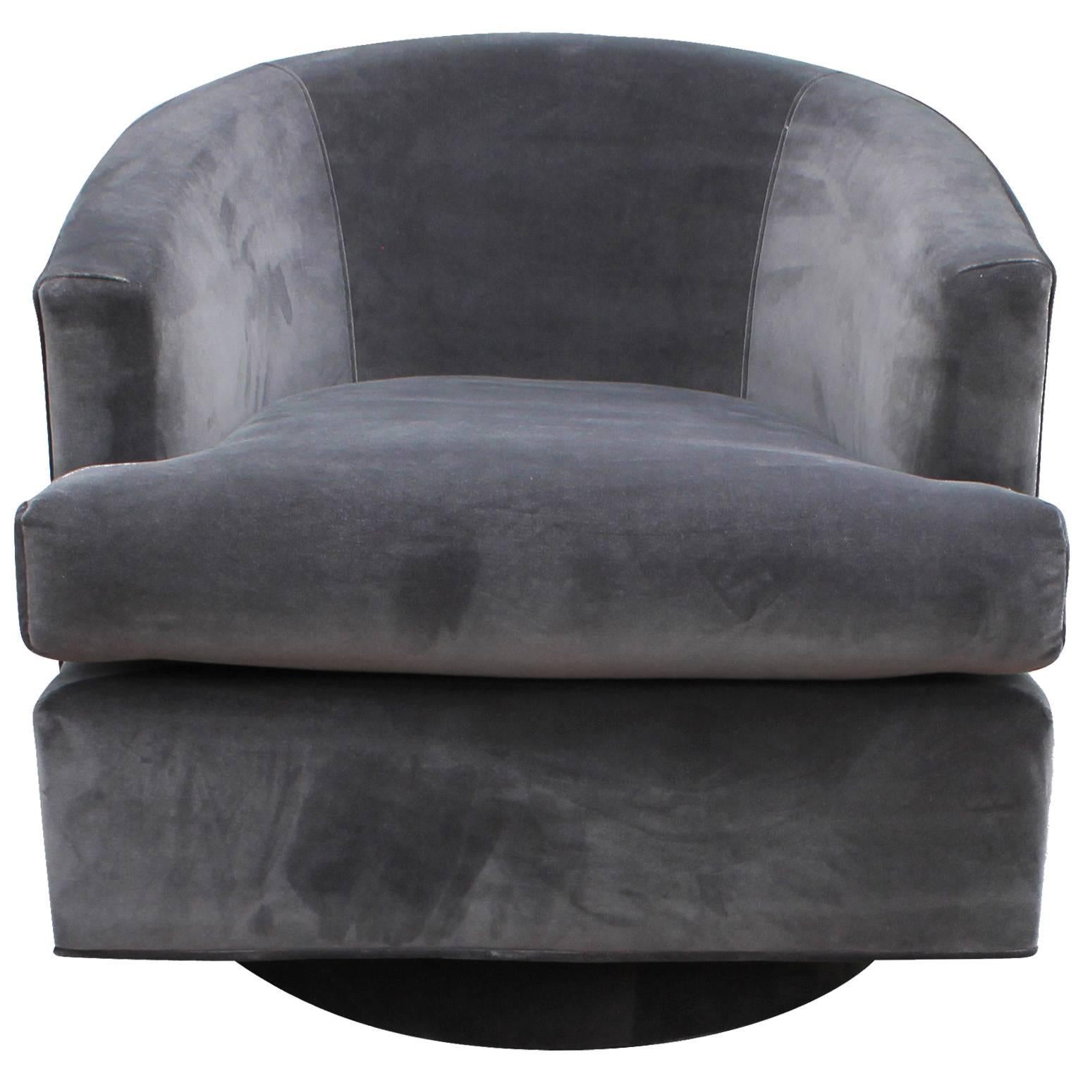 Wonderful pair of barrel back swivel chairs attributed to Milo Baughman. Chairs feature unique upholstered bases. Freshly upholstered in a luxe grey velvet.