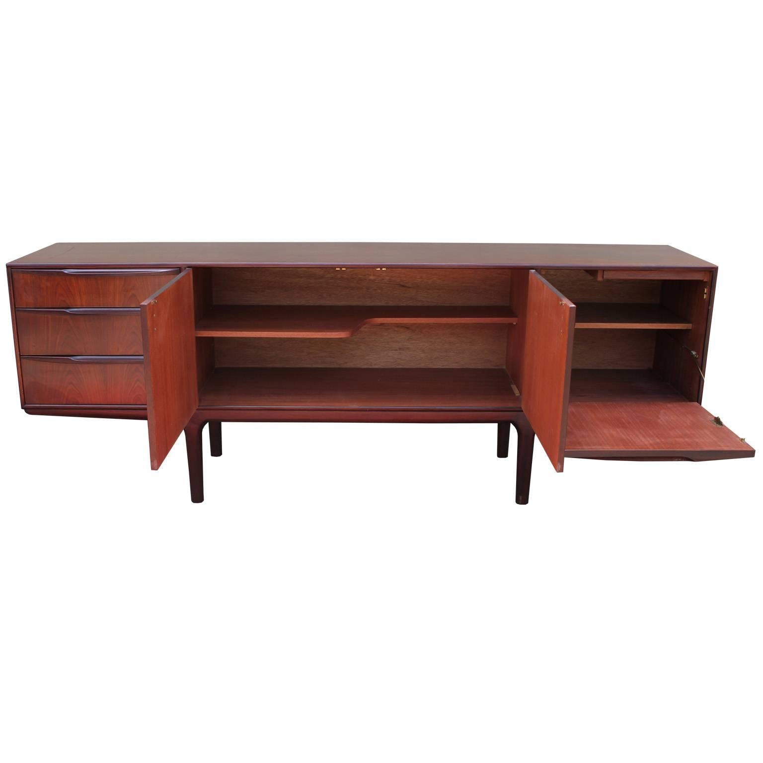 Fabulous McIntosh teakwood sideboard or credenza. Top of three drawers is slotted and lined for service. Two center cabinet doors open to reveal a shelf. Cabinet door on the right drops down to reveal a single shelf. Teak has an almost rosewood feel