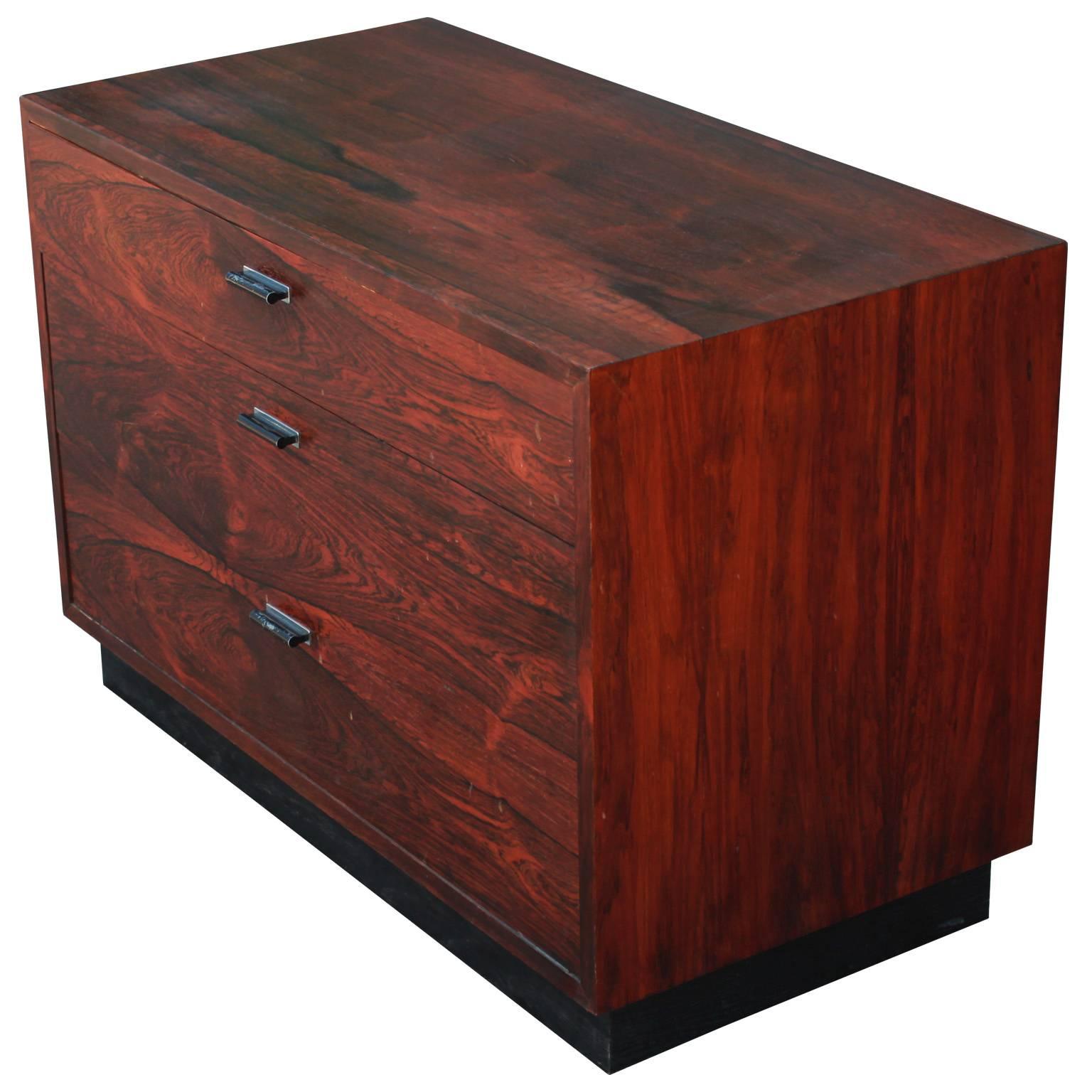 Excellent small-scale chest or side table designed by Harvey Probber. Rosewood has a dramatic matched grain and is truly stunning in person. Chest rests on a slightly inset black lacquered base. Black lacquered metal hardware has an excellent patina.