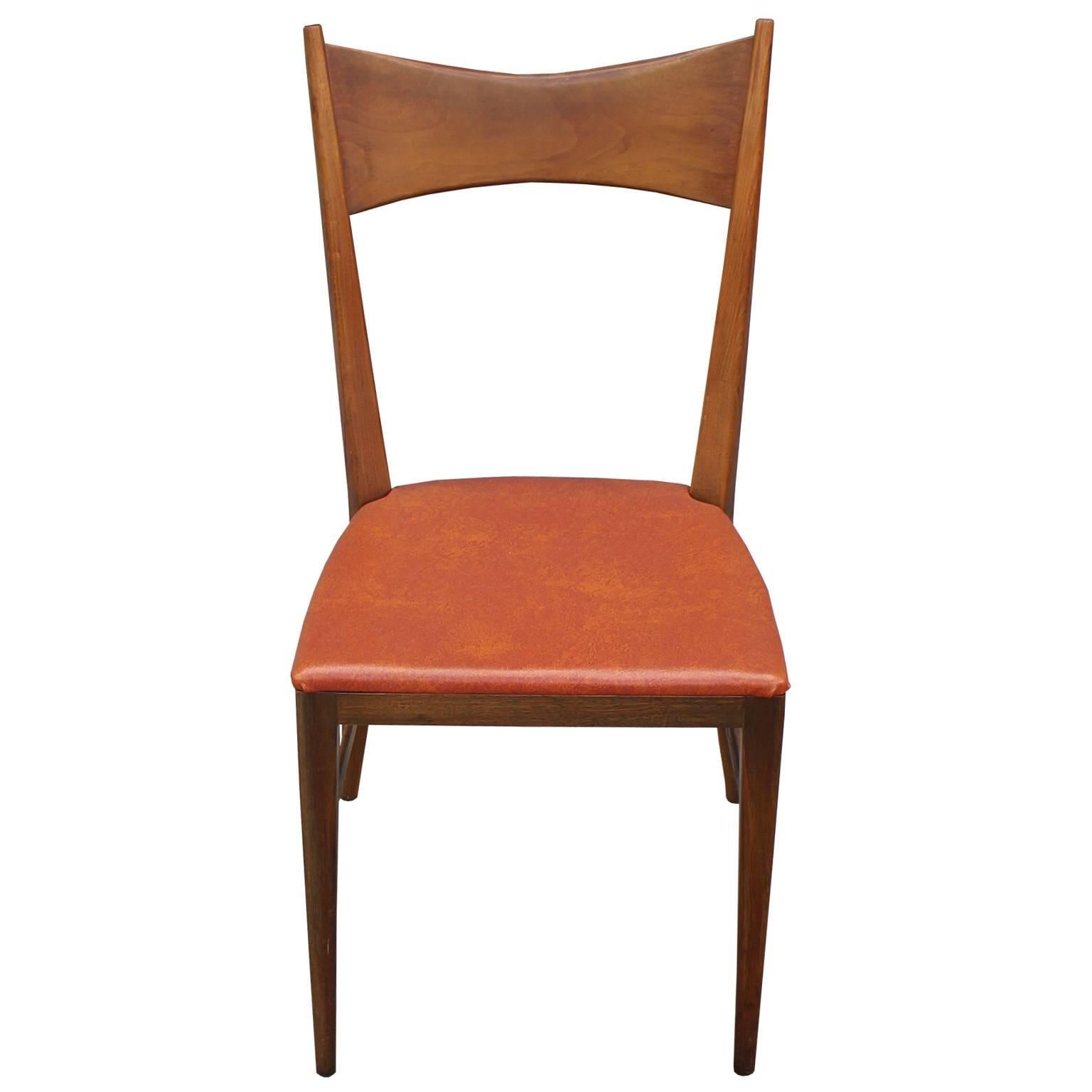 Beautiful set of six dining chairs designed by Paul McCobb. Walnut frames have stunning lines and are in excellent vintage condition. Chairs are upholstered in original orange vinyl which could be updated.