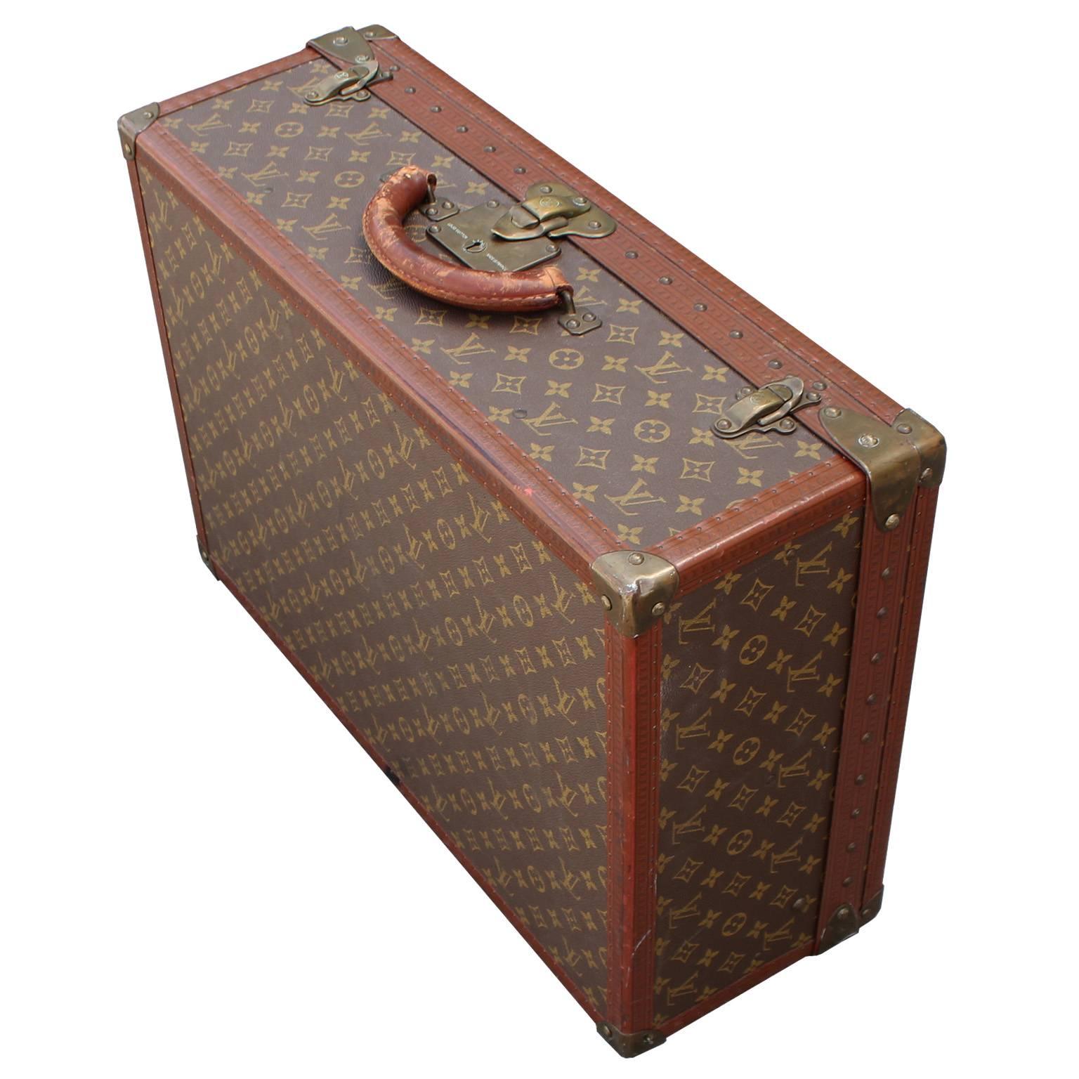 Elegant Louis Vuitton suitcase in the iconic monogram canvas. Brass fittings and leather trim have an excellent patina. Perfect accent to any space. Inquire for matching, smaller sized suitcase. There is one small flaw to the trim leather please