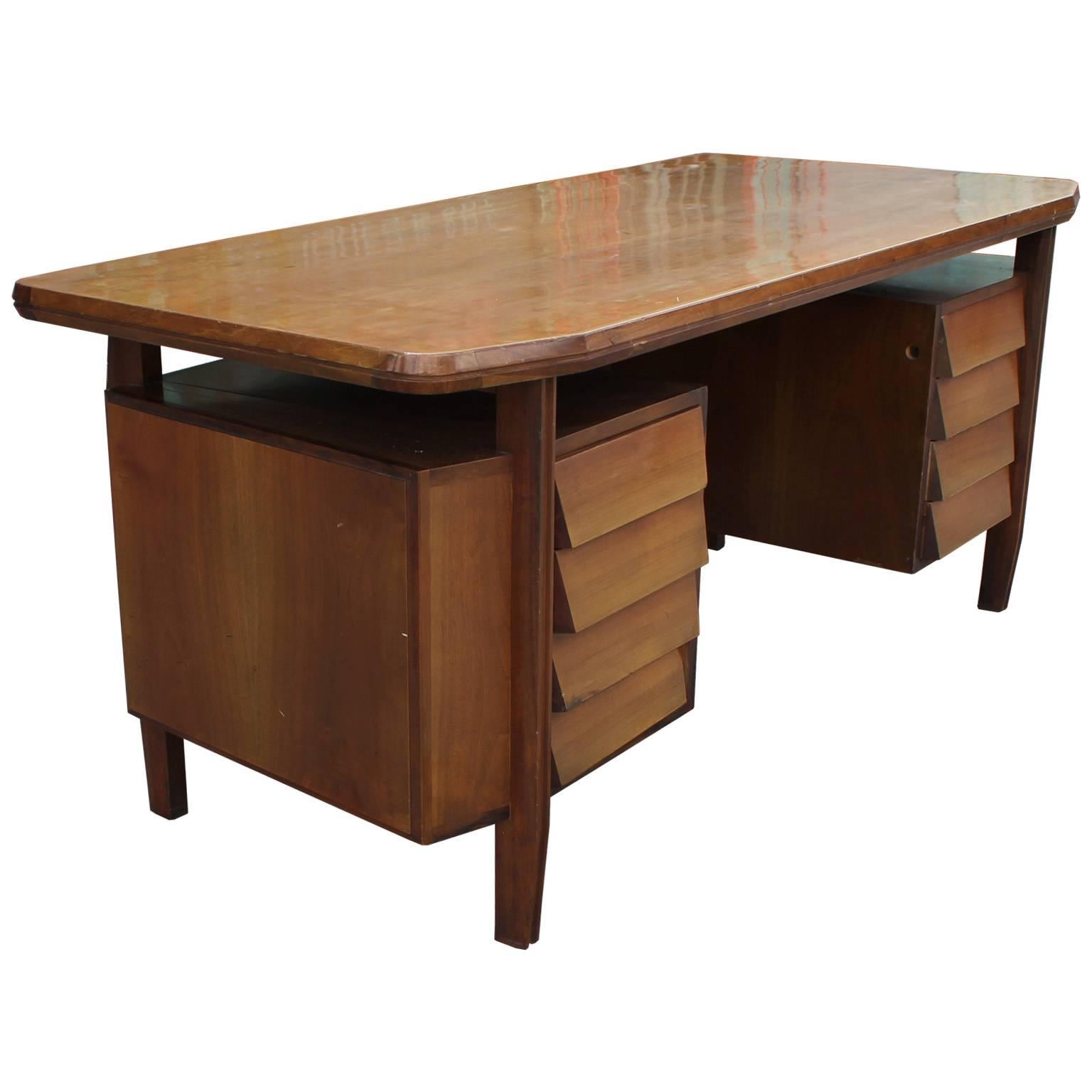 Gorgeous Mid-Century Modern Italian executive desk in the style of Gio Ponti. Features a beautiful blonde wood finish. Desk has great lines with the table top appearing to float over the double pedestals. Four drawers provide excellent storage. In