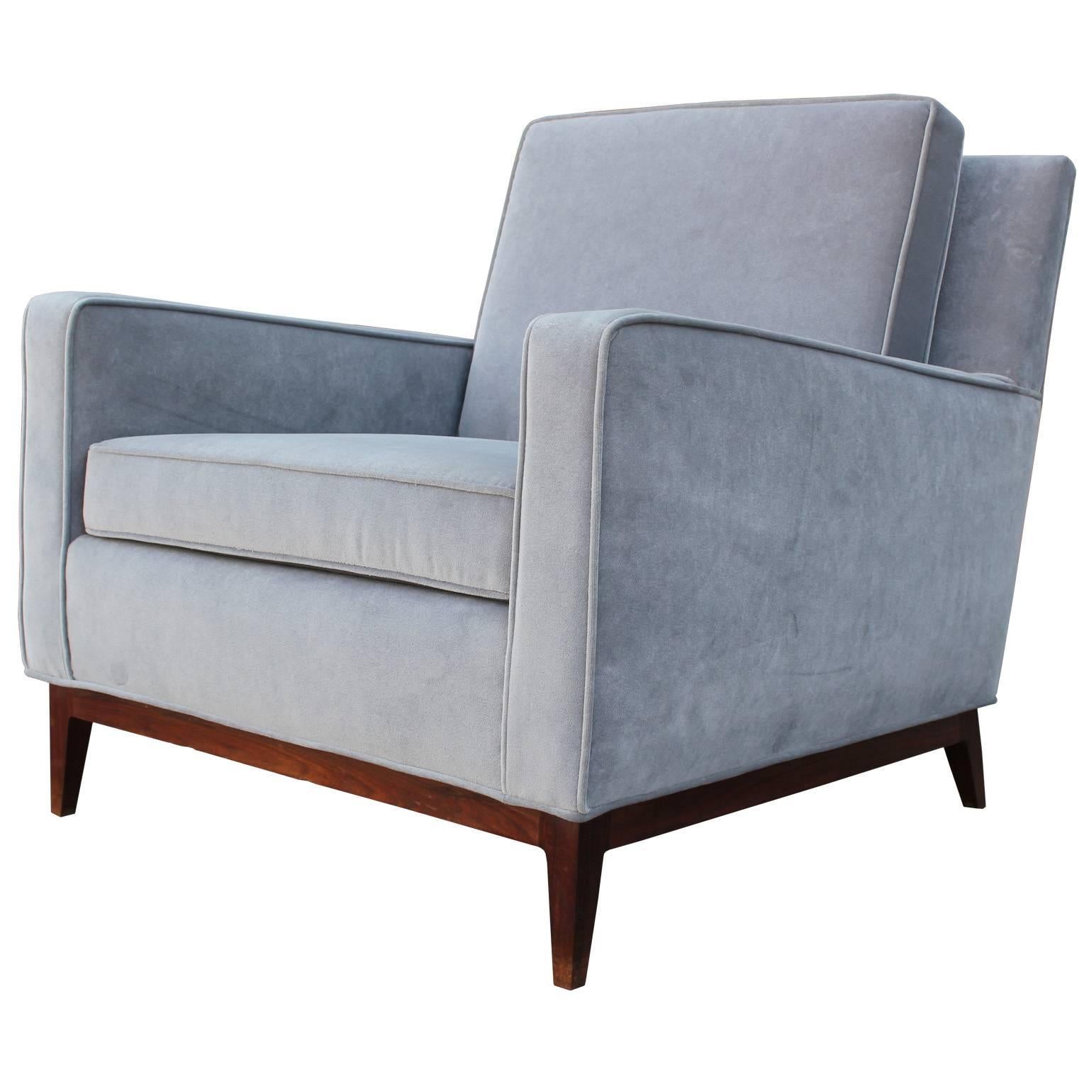 Wonderful pair of lounge chairs attributed to Paul McCobb. Chairs have perfect proportions and classic lines which make them perfect in virtually any interior. Chairs are freshly upholstered in soft grey velvet. Walnut bases complete the chairs.