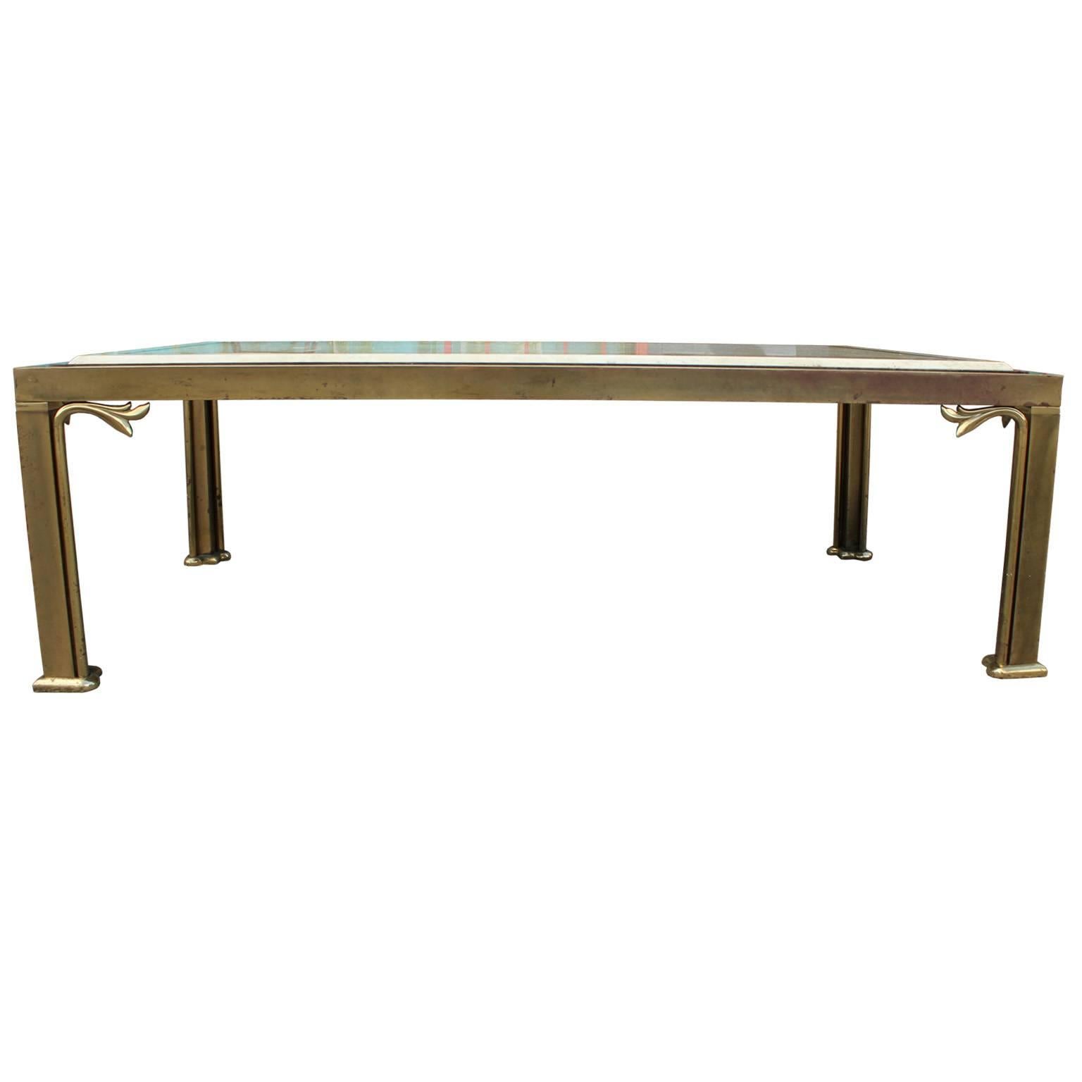 Elegant travertine topped coffee table. Brass table base has a clean feel with unexpected detailing. Travertine marble-top has an inlay detail. Perfect in a Hollywood Regency, transitional or modern space. Brass has a heavy patina.
