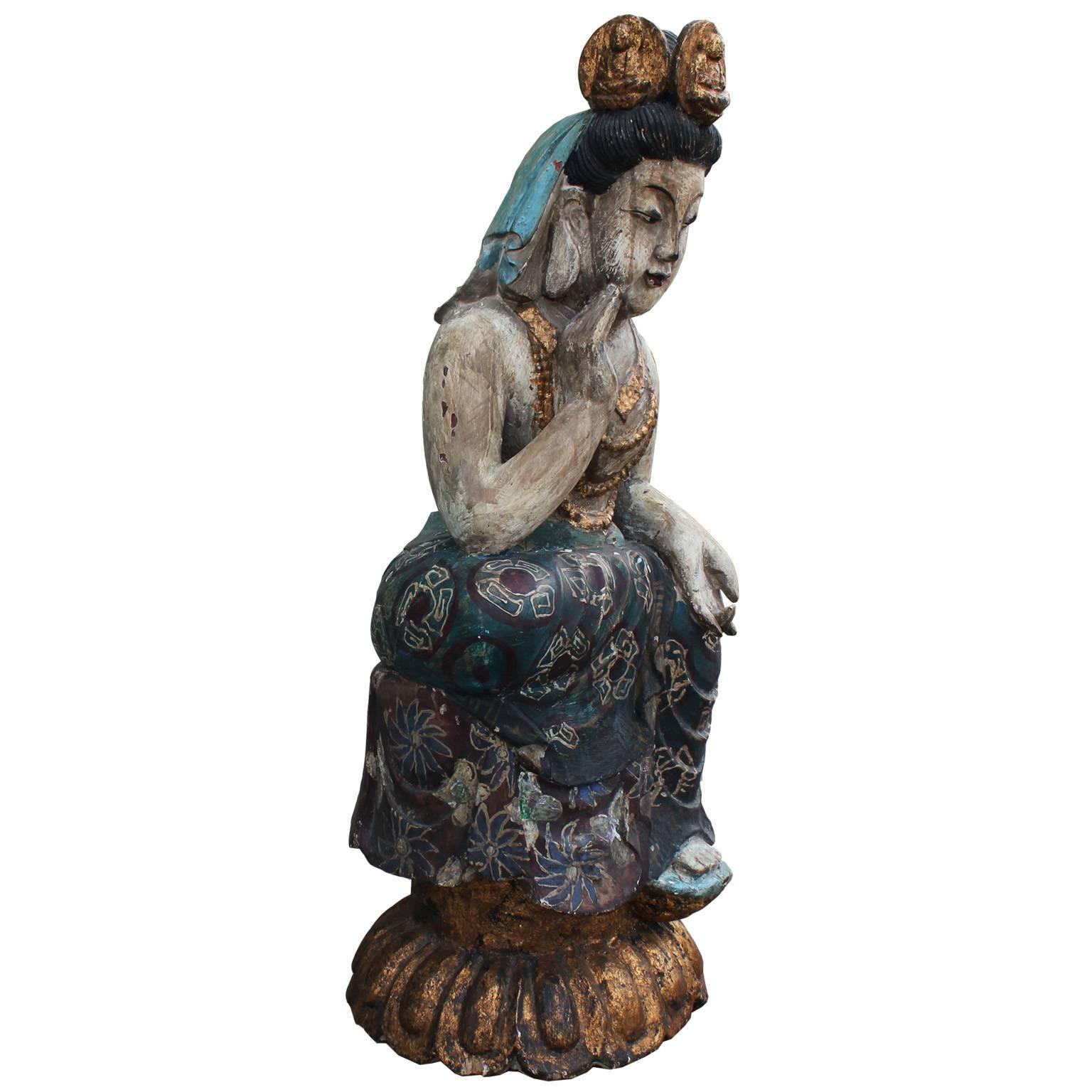 Beautiful carved wood seated Buddha statue. Buddha rests upon a gilt base with a gilt headdress and jewelry.