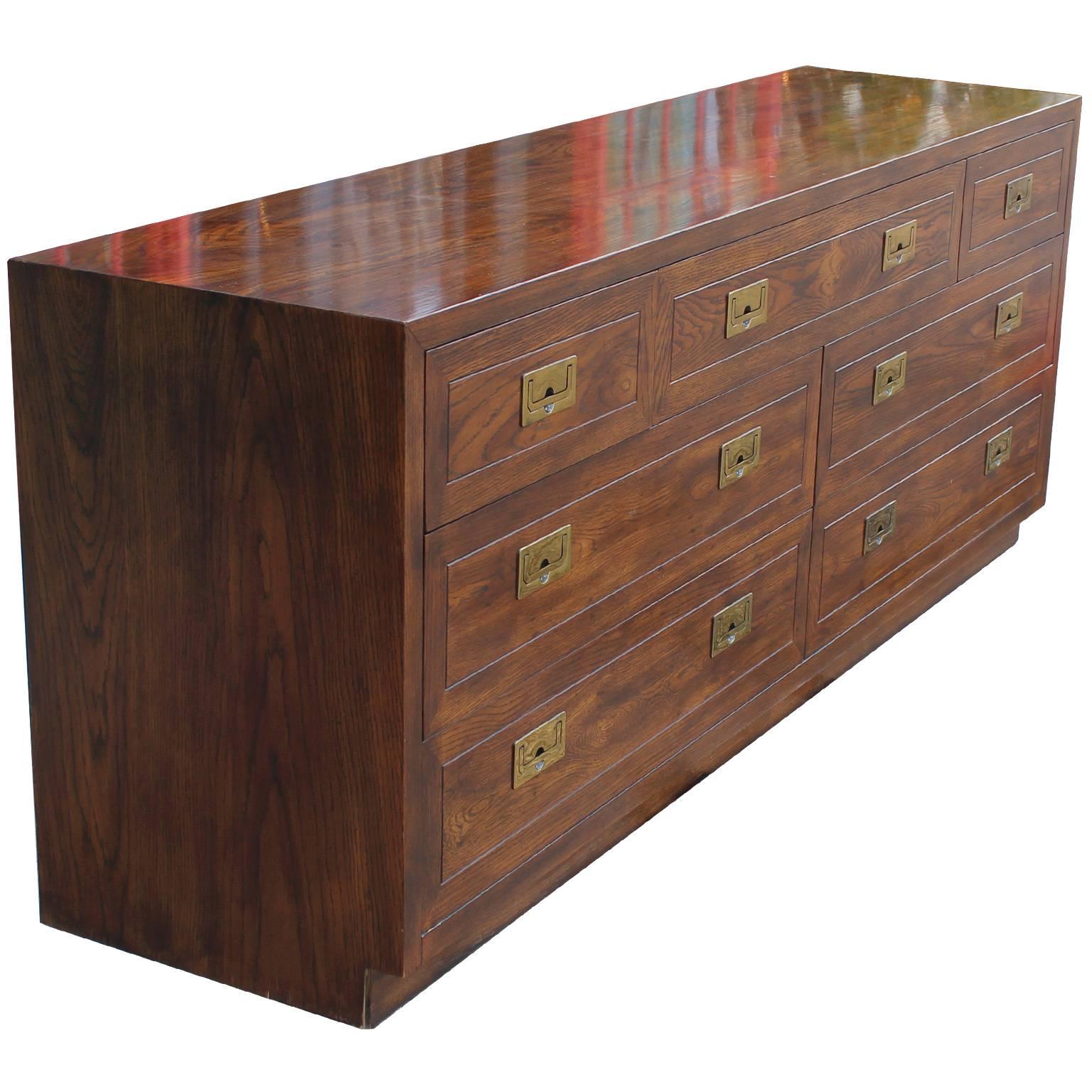 Wonderful Campaign style dresser. Dresser is of excellent craftsmanship and is constructed of a beautifully grained walnut. Seven drawers provide excellent storage. Shiny brass Campaign hardware finish the piece. Would be excellent in a Campaign,