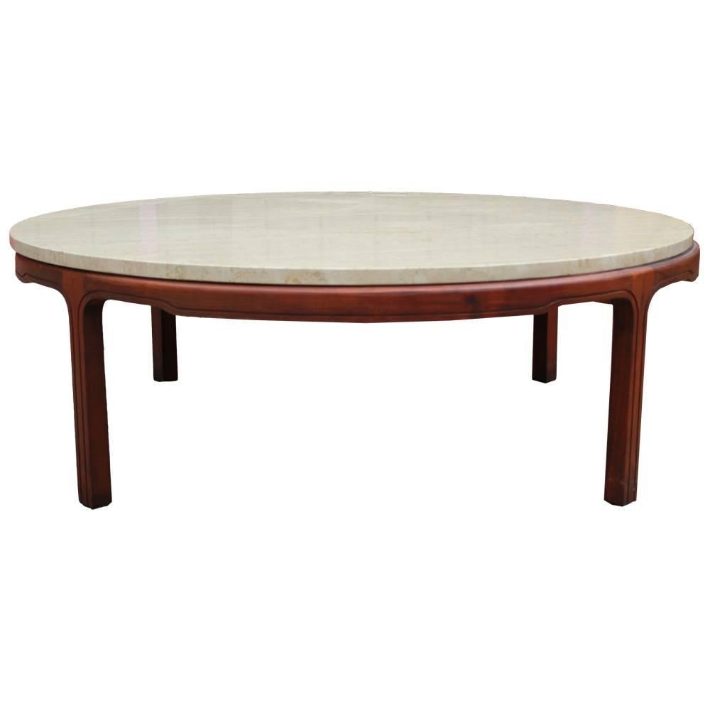Round travertine marble topped coffee table. Travertine top rests on a smple walnut base. Legs have very subtle detailing. In the style of Baker or Dunbar.