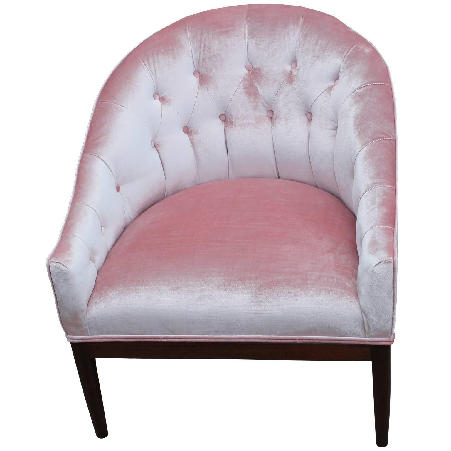 Glamorous pair of barrel back lounge chairs. Chairs are upholstered in a luxe, silky pale pink velvet. Tufting adds visual interest and comfort. Bases are finished in a dark walnut. Perfect in a Hollywood regency or Mid-Century space.
