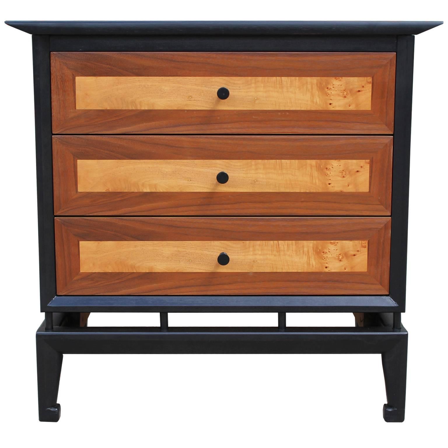 Wonderful pair of Asian influence nightstands or side tables. Cases are finished in an ebony stain which nicely showcases the two-tone natural drawer fronts. Three drawers provide excellent storage. Stunning from all angles.