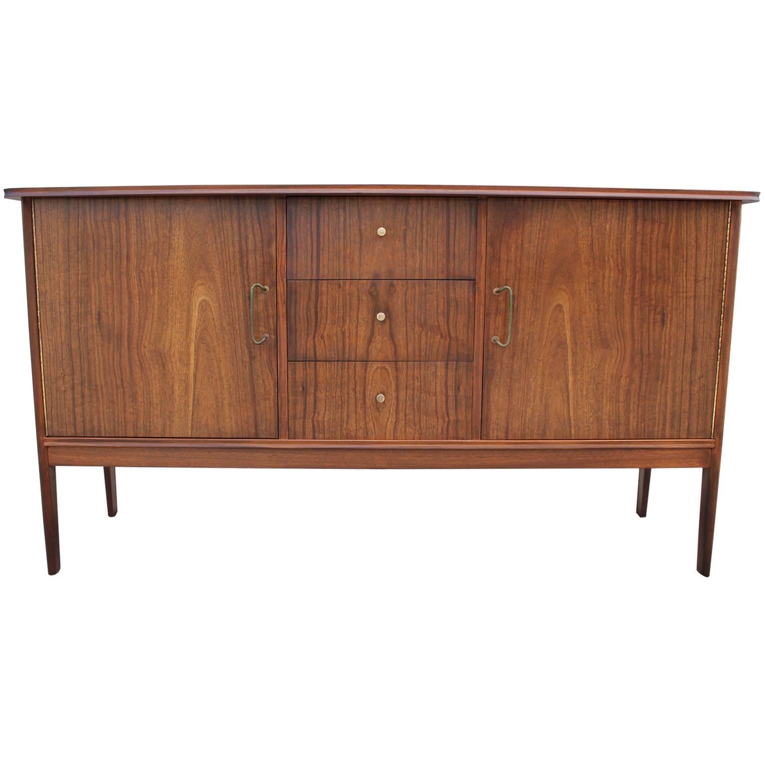 Beautiful walnut credenza or sideboard. Walnut has a beautiful, matched butterfly grain. Two cabinet doors each open to a single shelf. Three drawers provide additional storage. Brass hardware has an excellent patina.